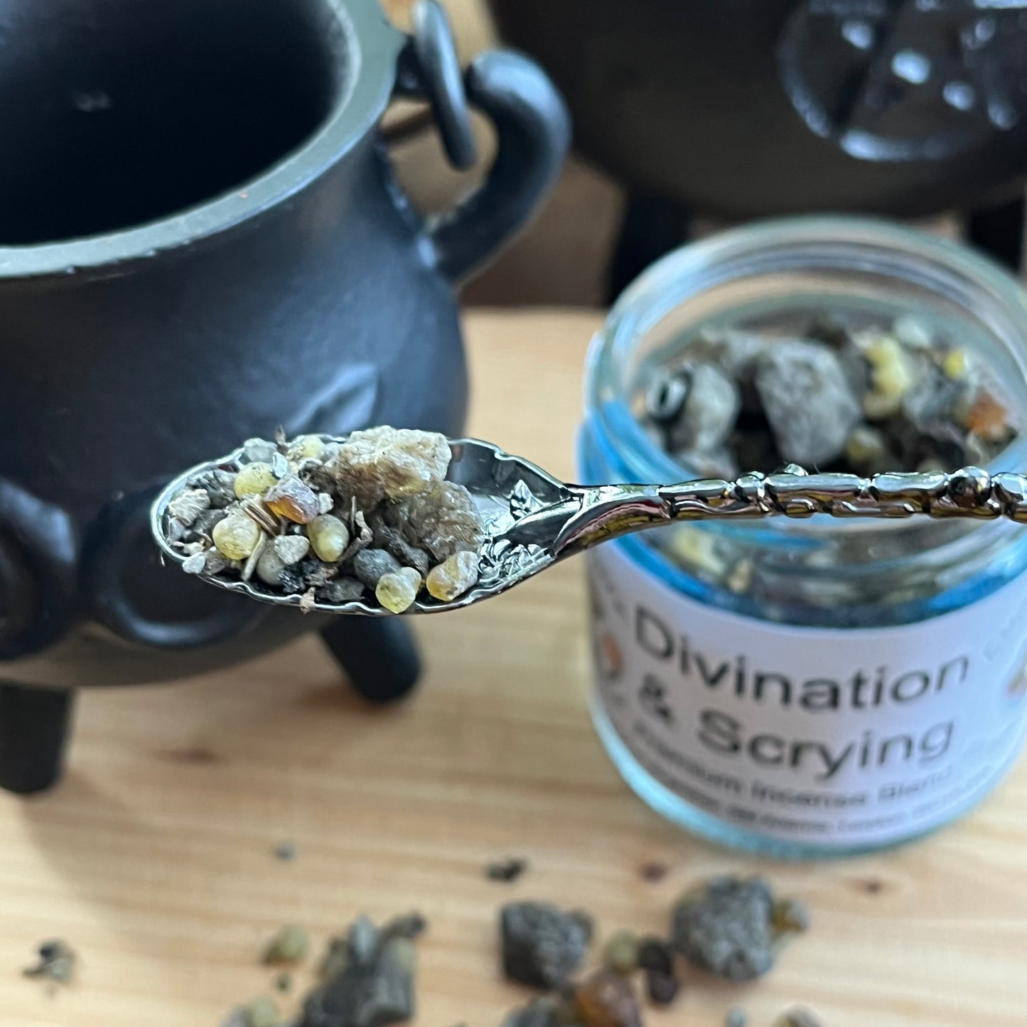 Spoonful of incense herbs with 'Divination & Scrying' jar in the background
