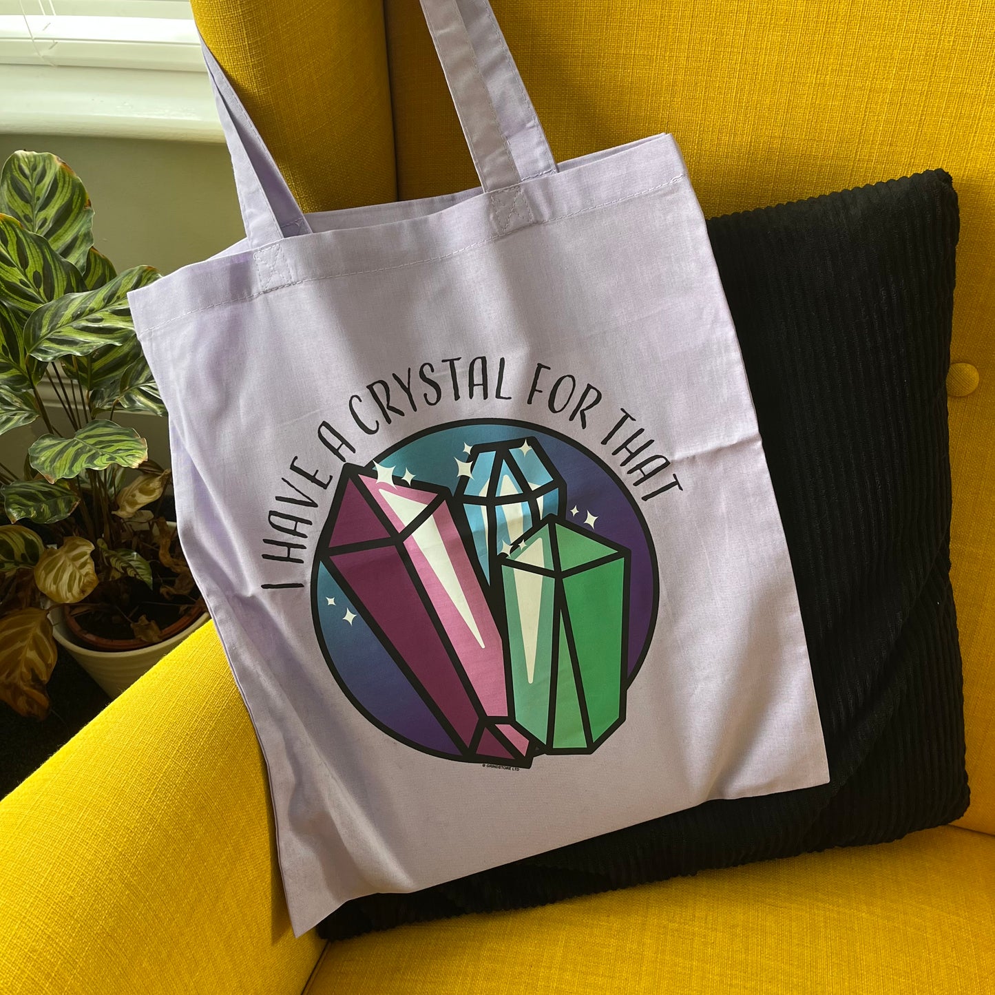 Tote bag with crystal design and text on a yellow couch