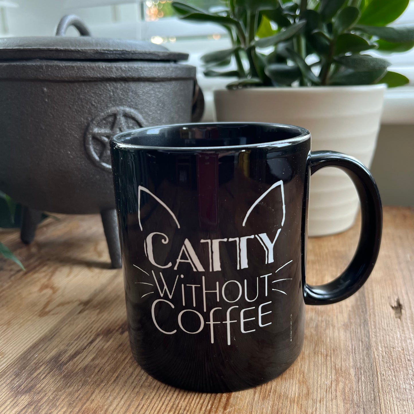 Black mug with the words 'caty without coffee' in white and an illustration of cats ears and whiskers