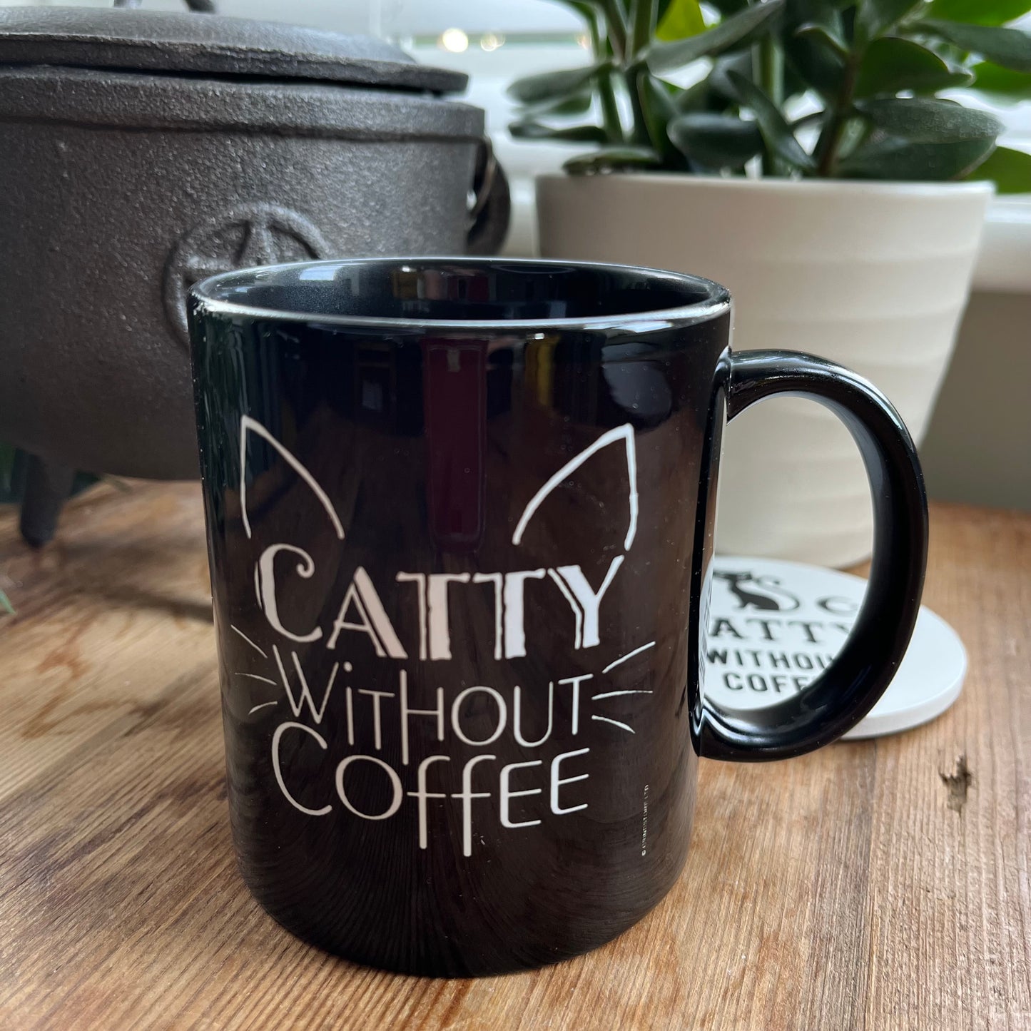 Black mug with the words 'caty without coffee' in white and an illustration of cats ears and whiskers