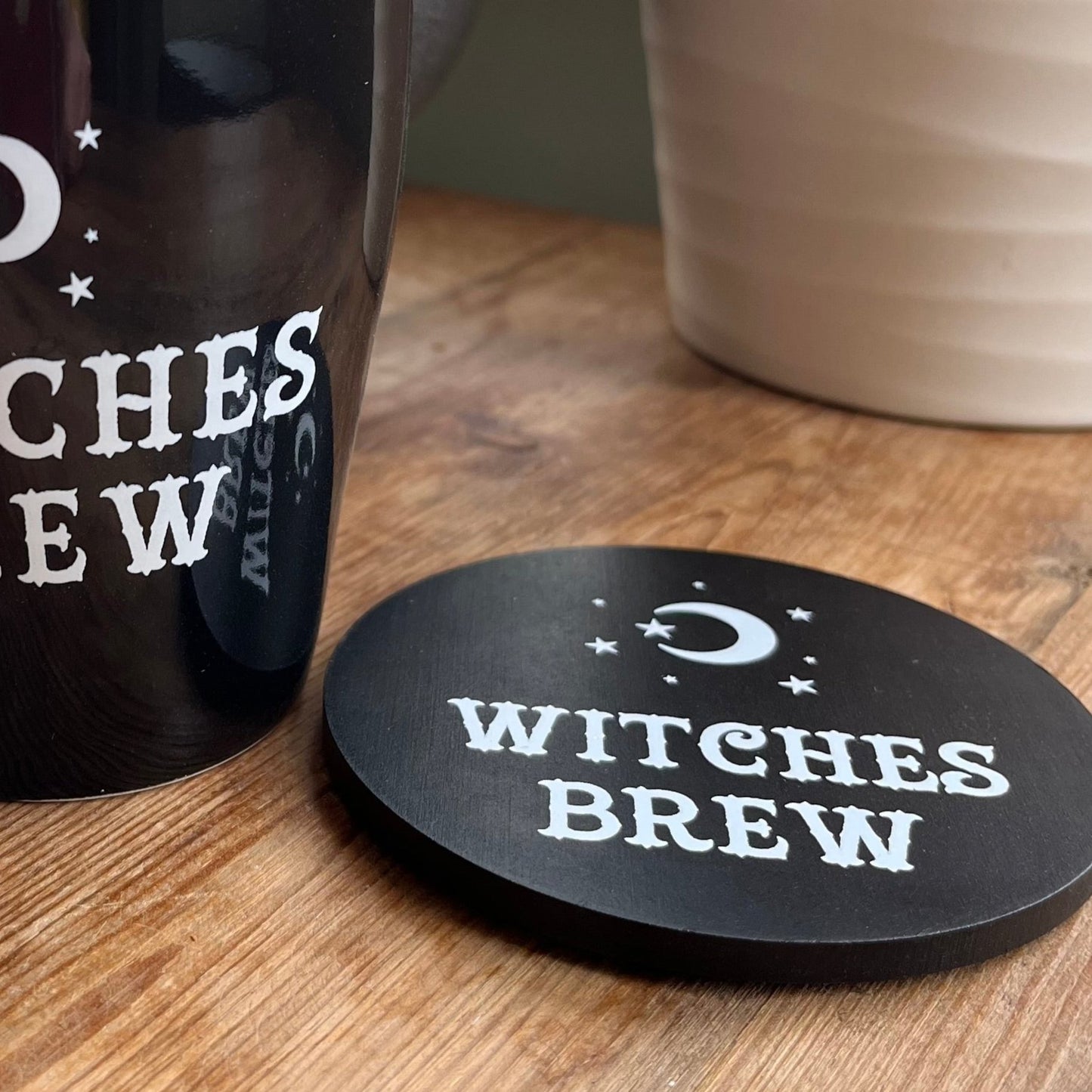 Black Coaster with the words 'witches brew' in white cursive text