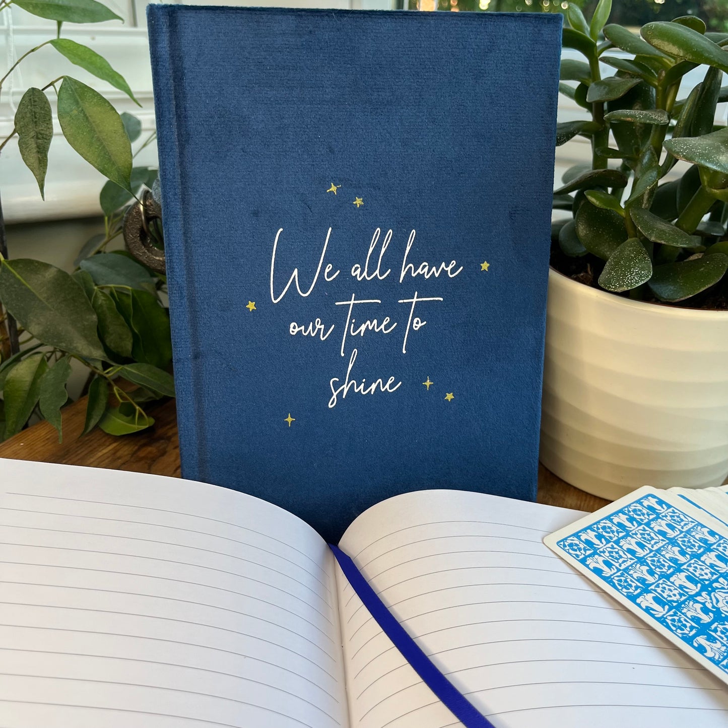 Blue velvet A5 notebook features words 'we all have our time to shine' A second notebook shows the lined pages and blue ribbon page divided inside the notebook