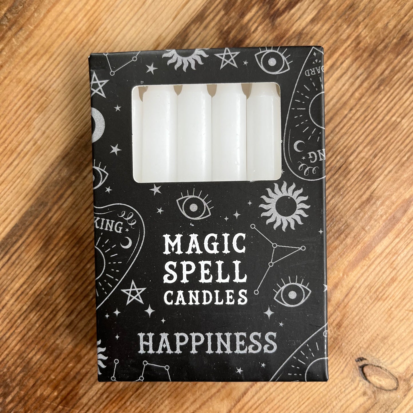 Black box containing 12 white spell candles the box reads magic spell candles for happiness
