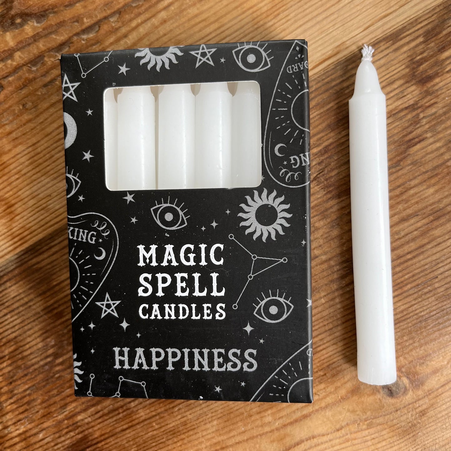 Black box containing 12 white spell candles the box reads magic spell candles for happiness