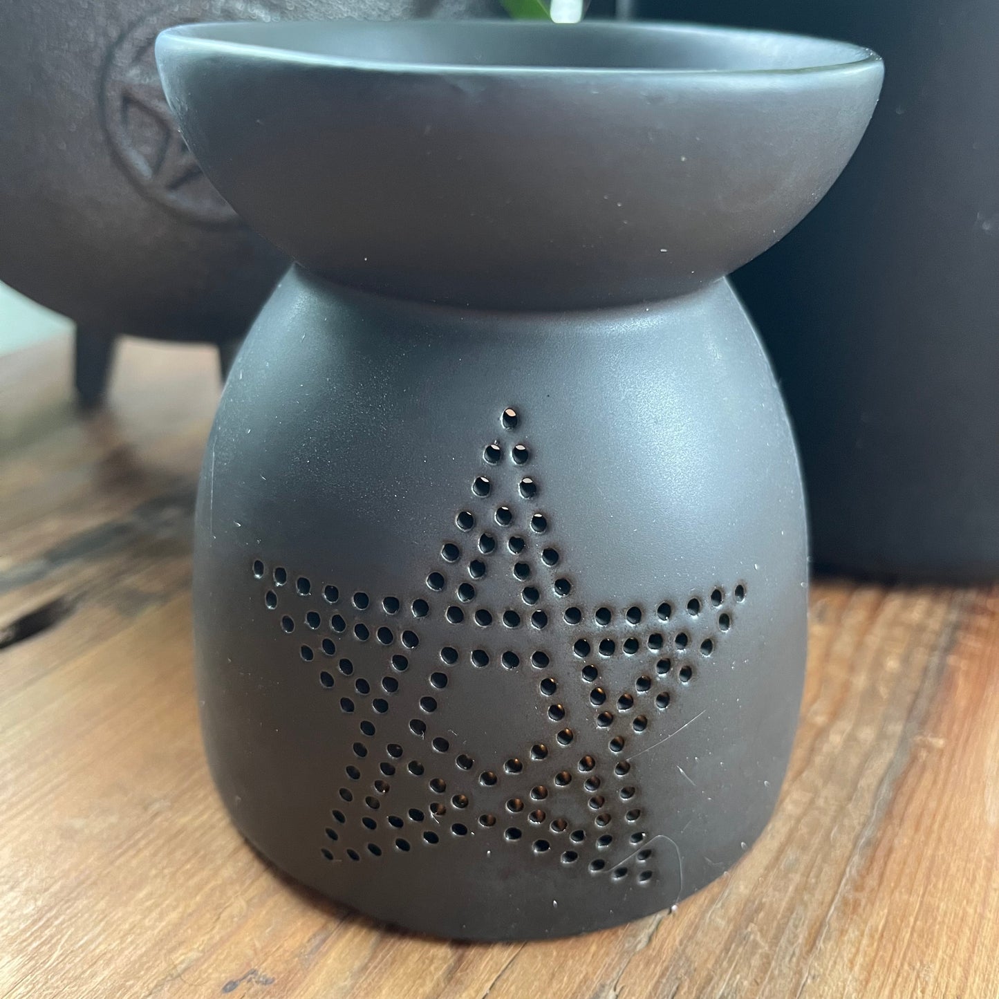Black ceramic oil burner, featuring a pentagram cutout design and a smooth matte finish.