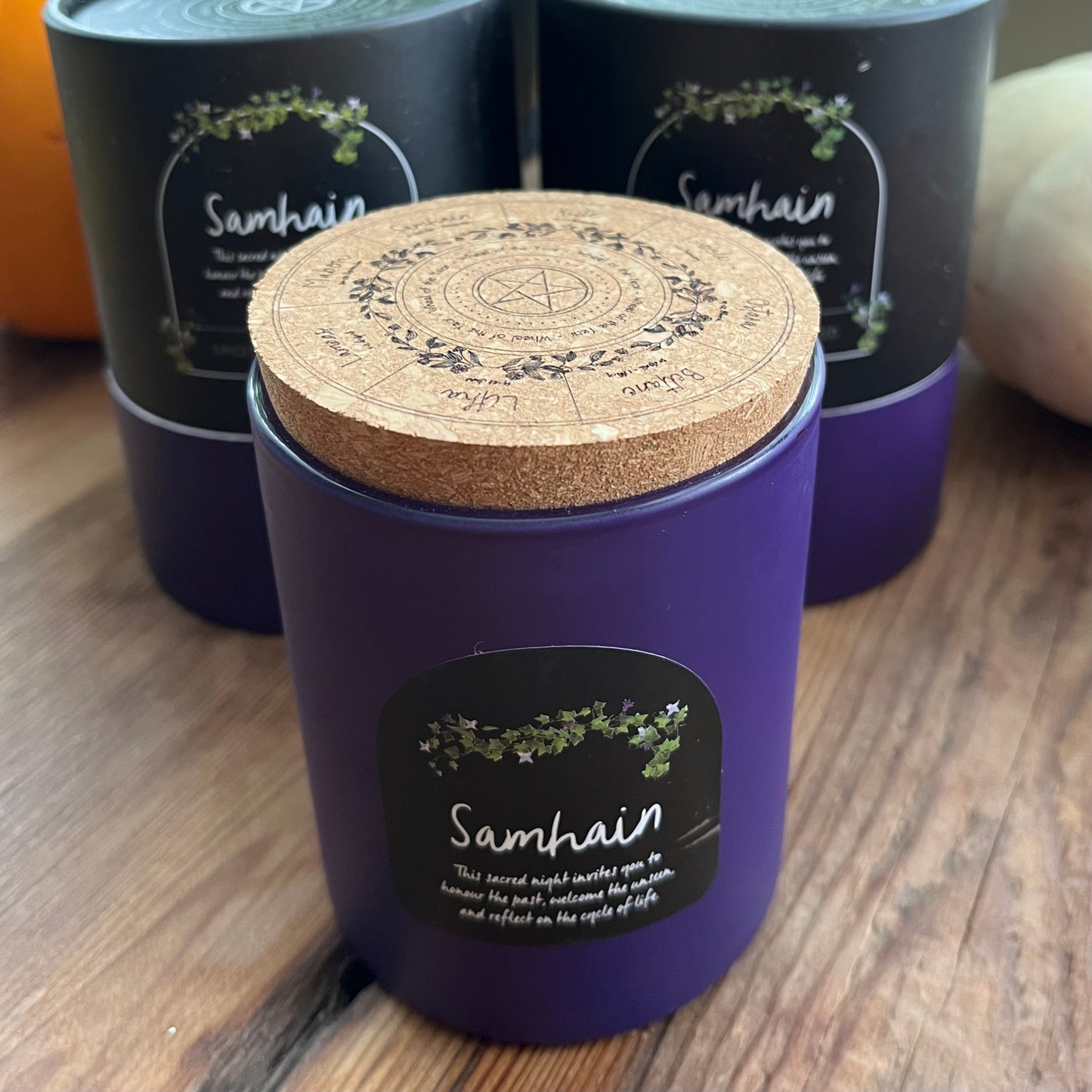 Purple Samhain candle with cork lid on a wooden surface