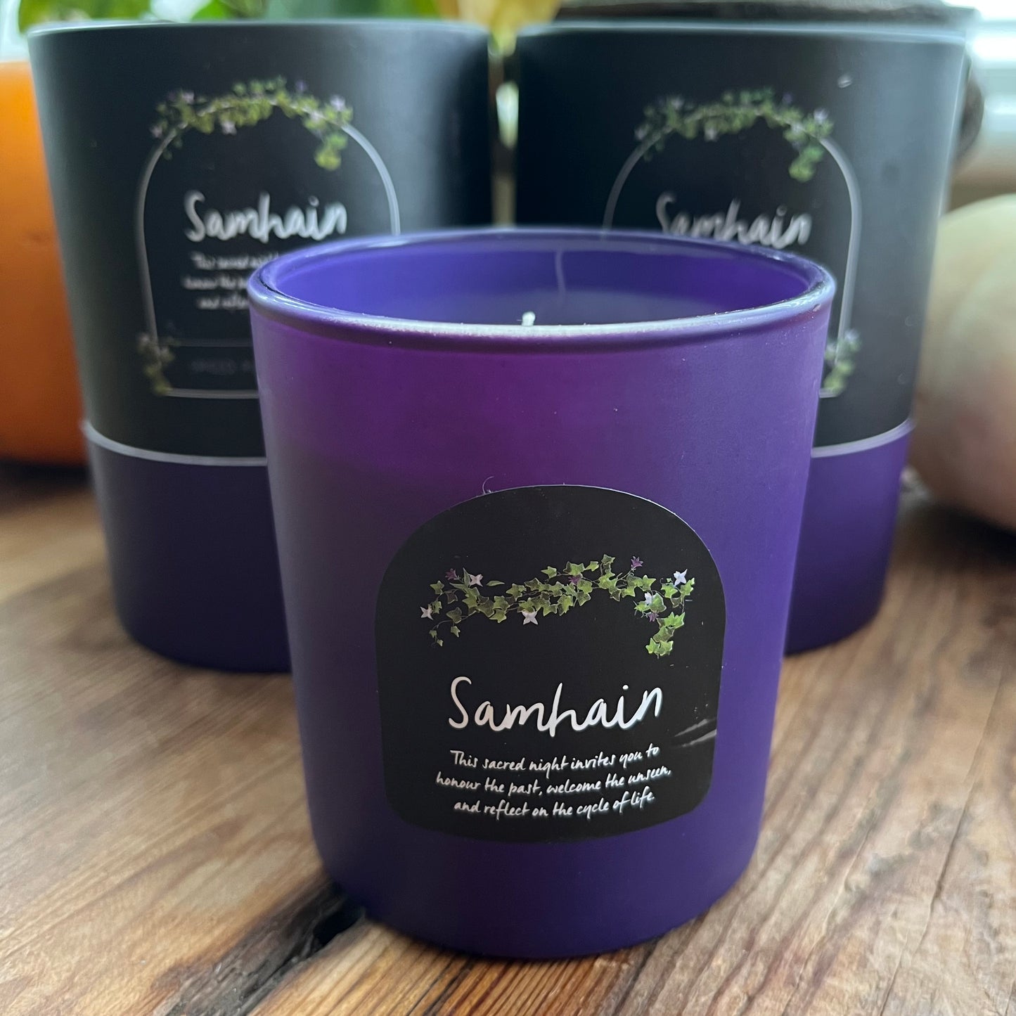 Purple Samhain candle with a label on a wooden surface