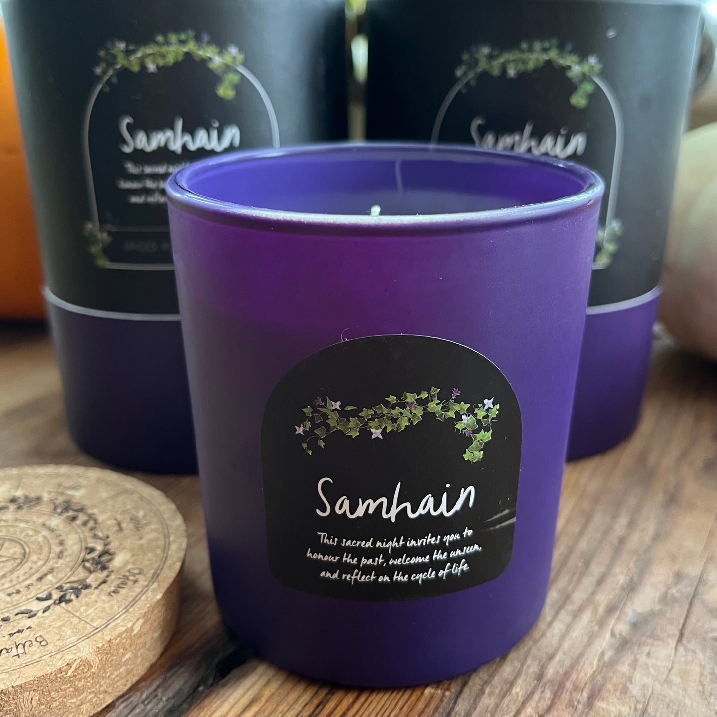 Purple candle with 'Samhain' label on a wooden surface