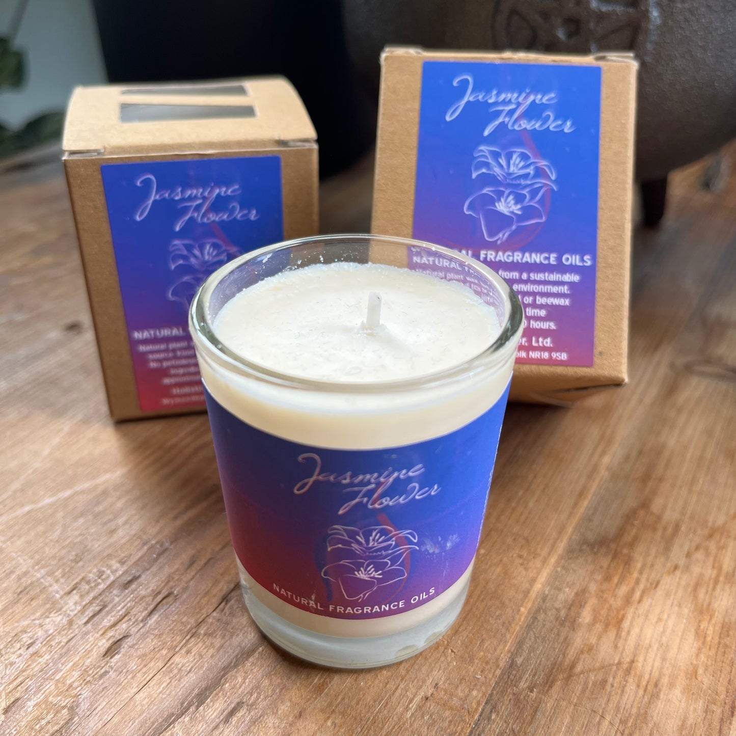 White votive candle with purple label stating it is a natural fragranced Jasmine candle comes boxed