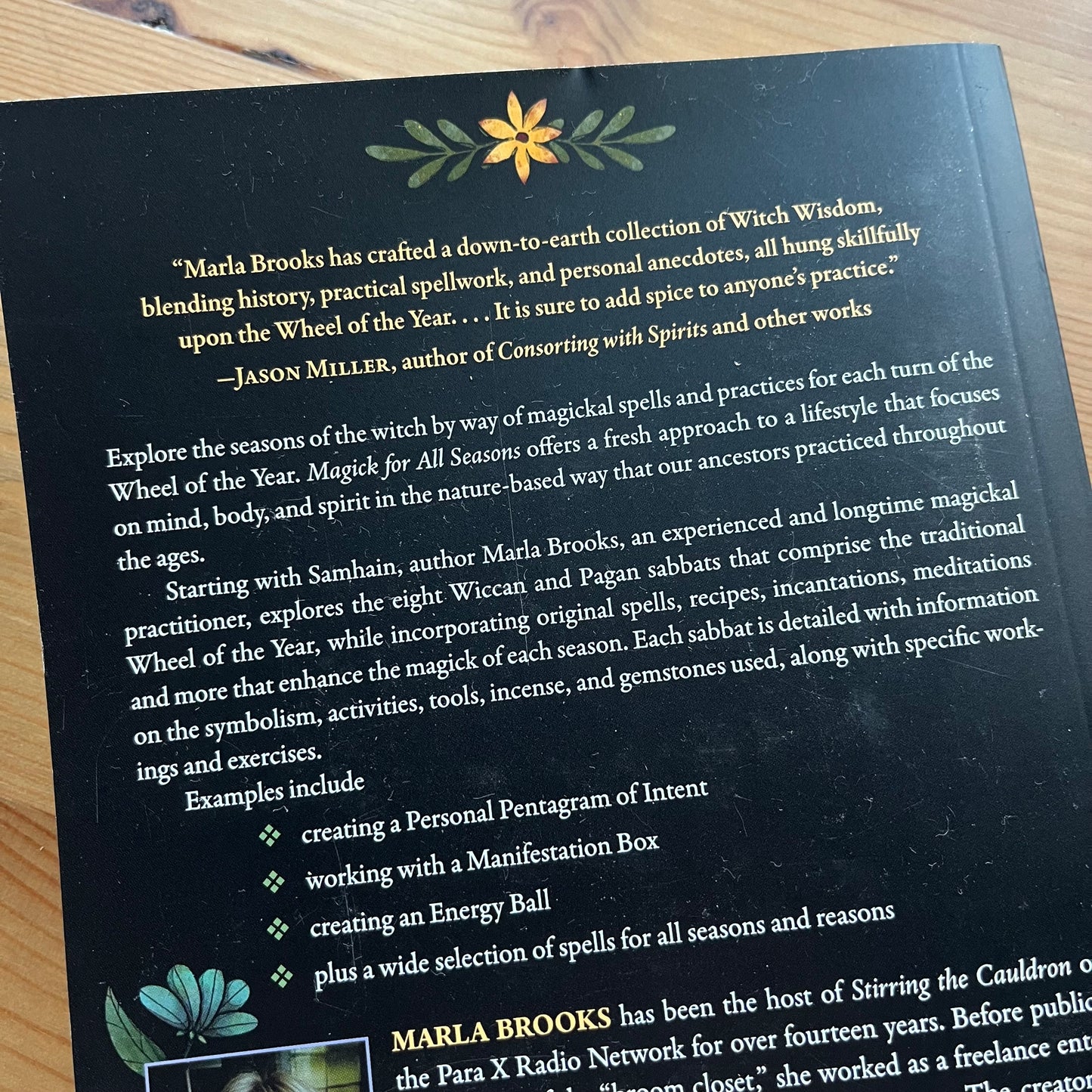 Book cover with text and decorative elements on a wooden surface