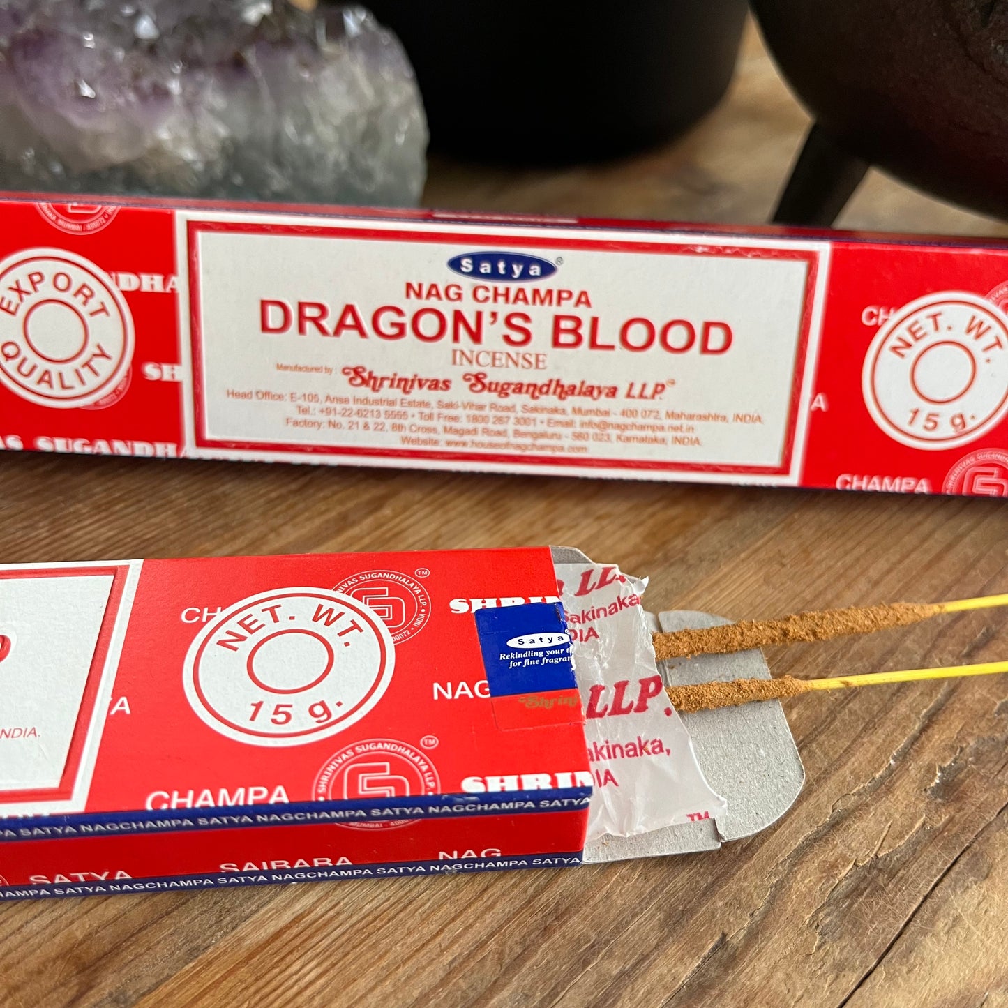 2 packages of Dragons Blood incense by Satya Nag Champa Incense LTD, with red and white color scheme. One packet is open and some incense sticks are peeking out