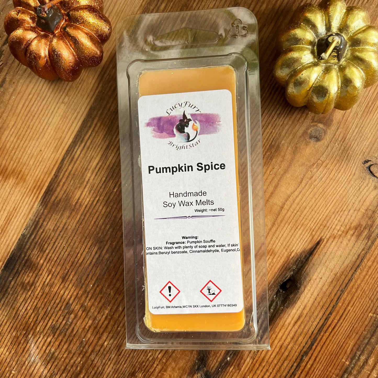Pack of Pumpkin Spice soy wax melts on a wooden surface with decorative pumpkins.