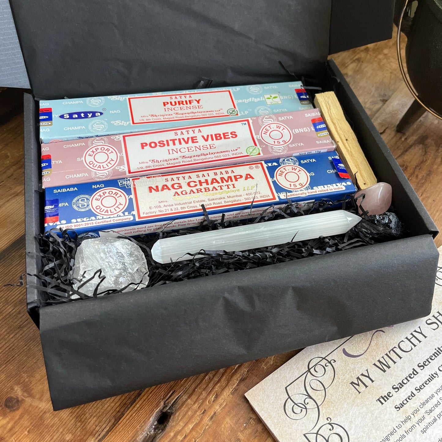 Box containing Satya incense sticks and other items on a wooden surface