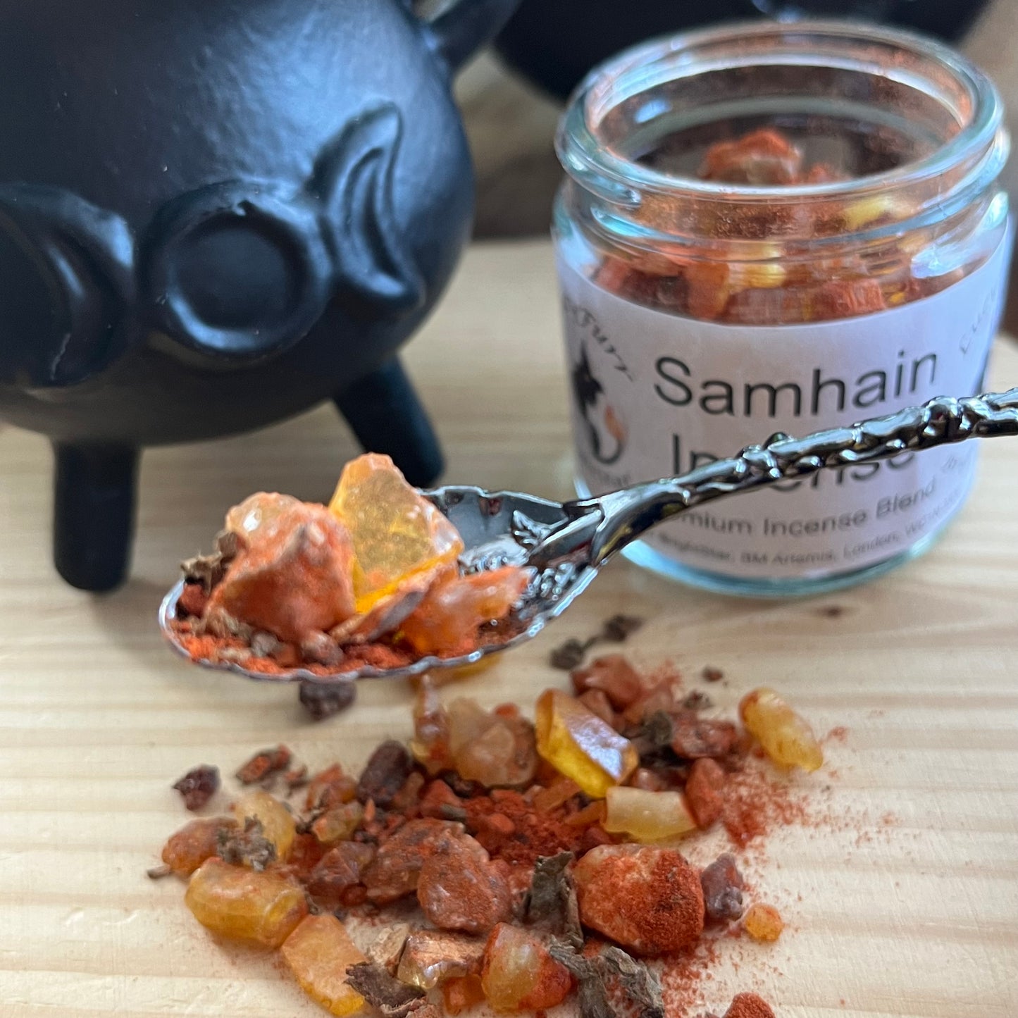 Incense on a spoon with a jar labeled 'Samhain' in the background