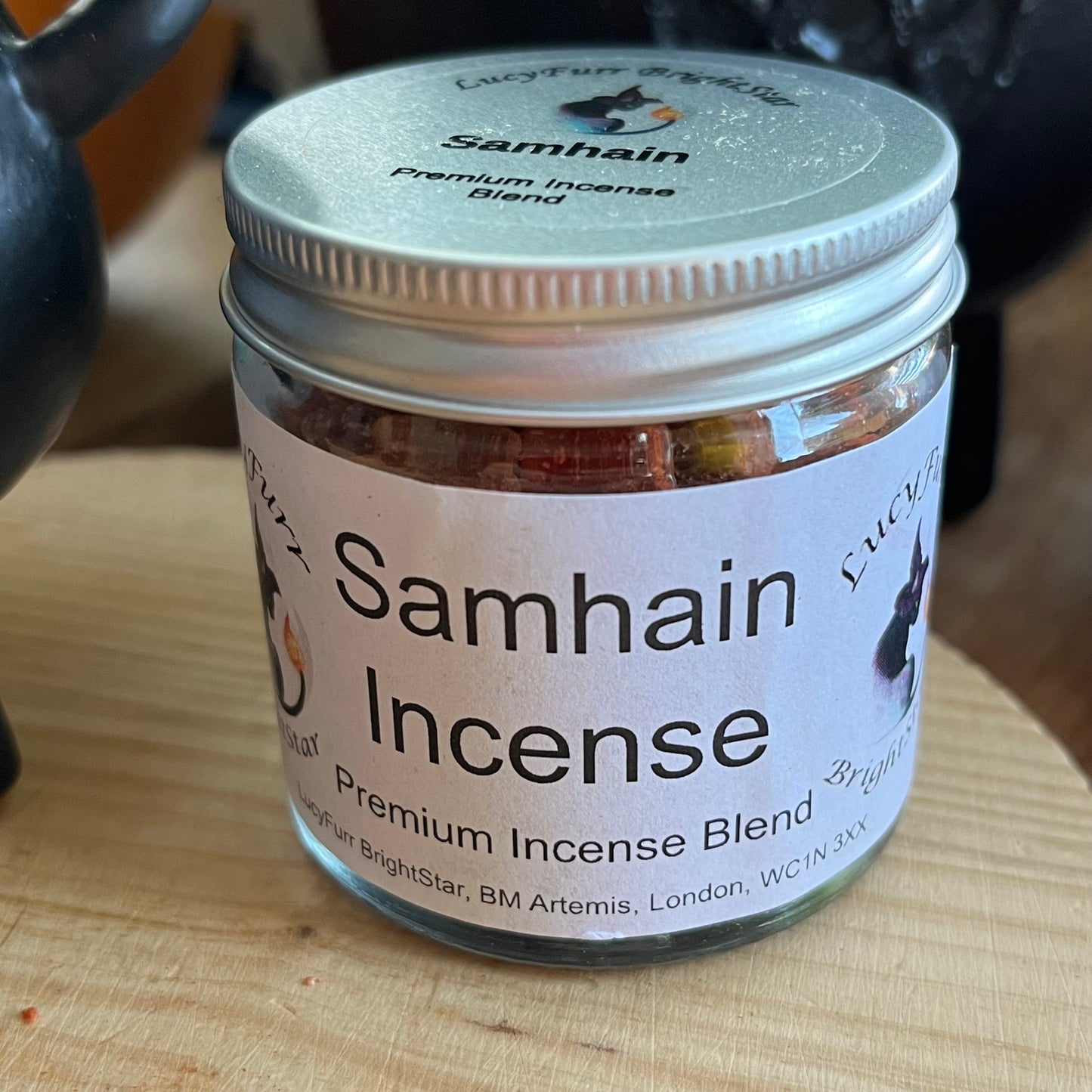 Jar of Samhain Incense with a visible label on a wooden surface