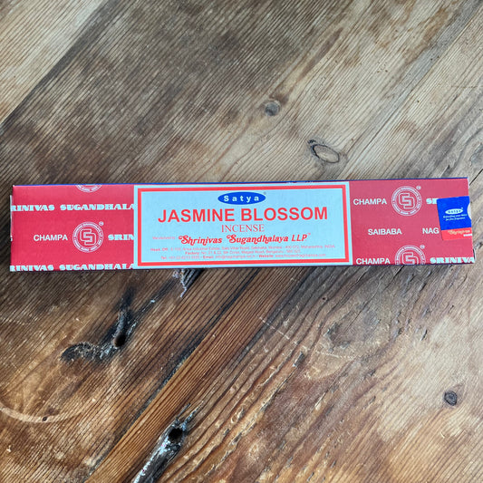 A box of Satya Jasmine Blossom incense on a wooden surface.