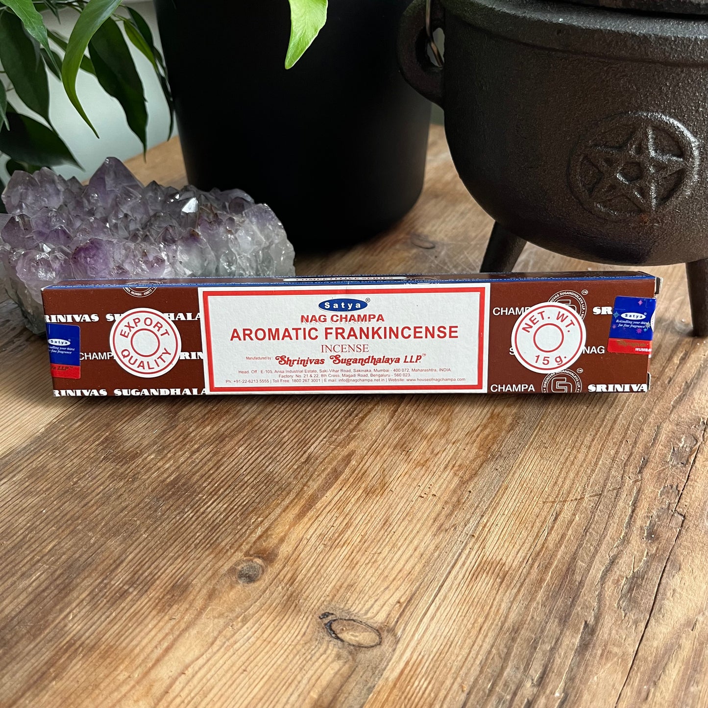 A package of Satya Nag Champa Aromatic Frankincense incense is displayed on a wooden surface.