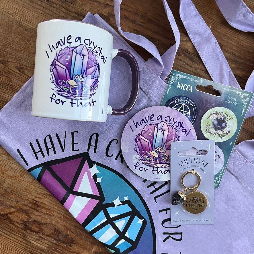 Wicca-themed mug, keychain, and stickers on a purple fabric background
