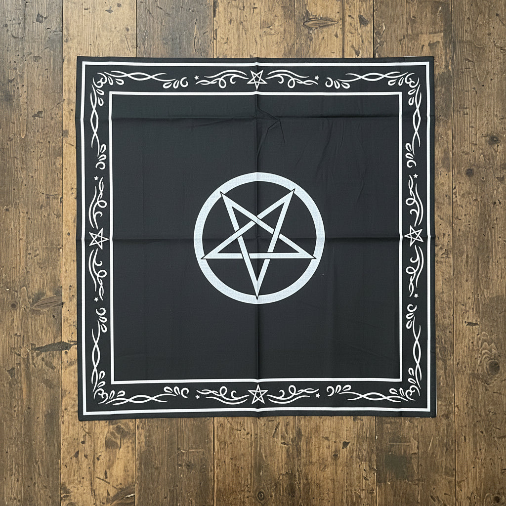 A square Altar Cloth featuring a white pentagram inside a circle at the center and an ornate white decorative border around the edges, laid flat on a dark textured surface.
