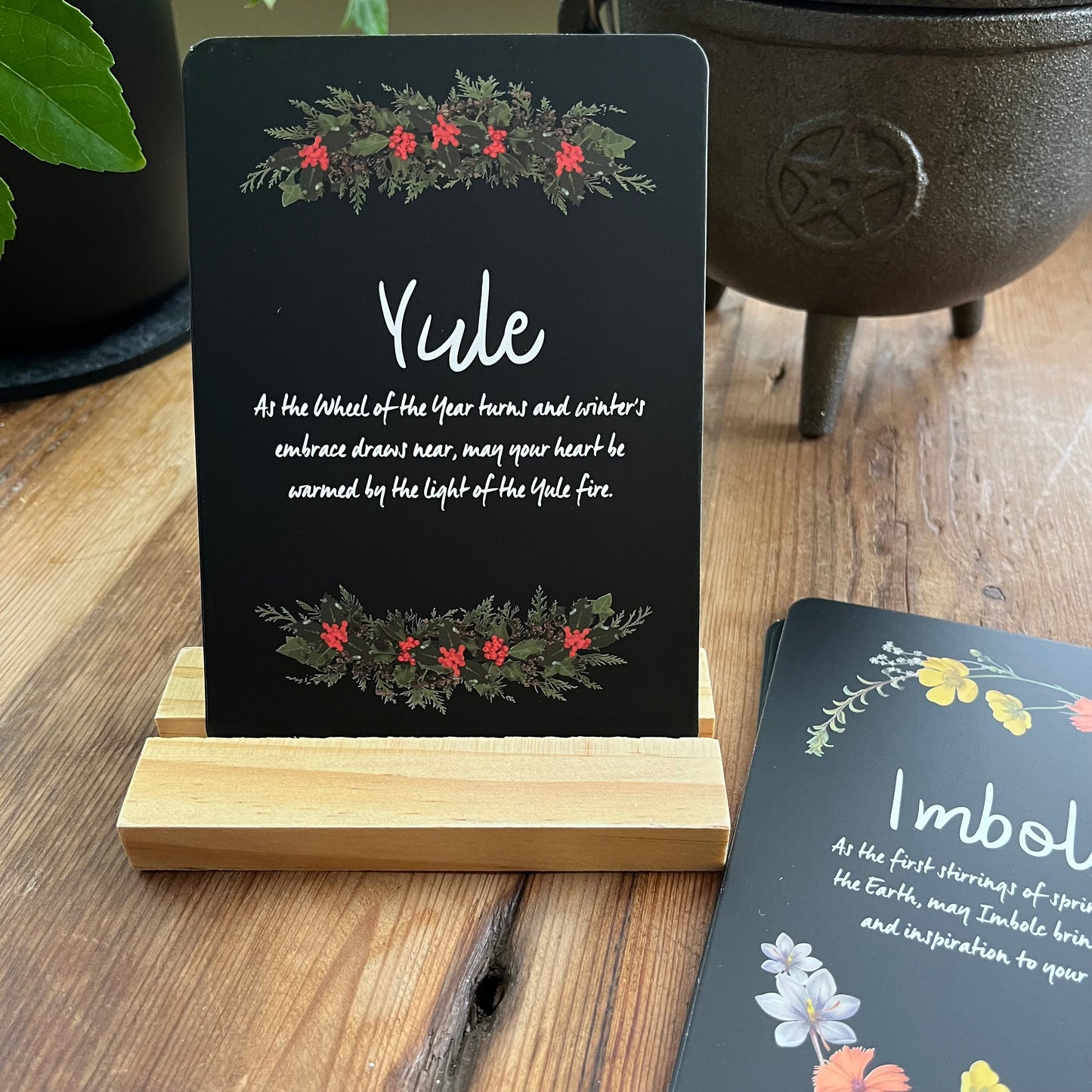 Decorative Altar card with 'Yule' text and festive design on a wooden stand, with another card in the background.