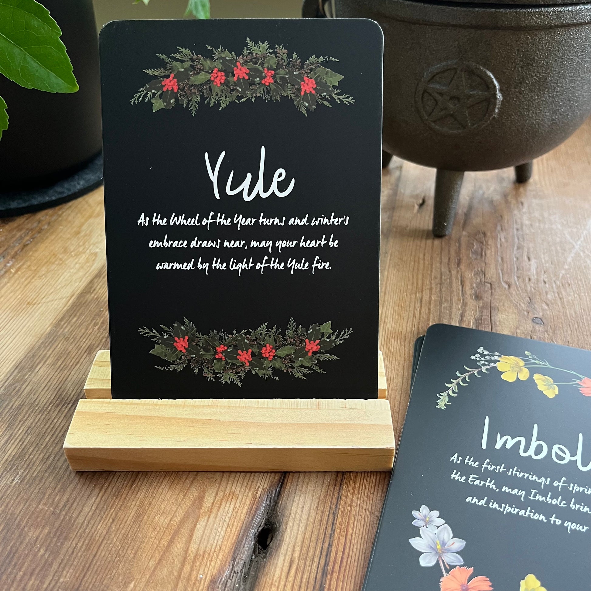 Decorative Altar card with 'Yule' text and festive design on a wooden stand, with another card in the background.