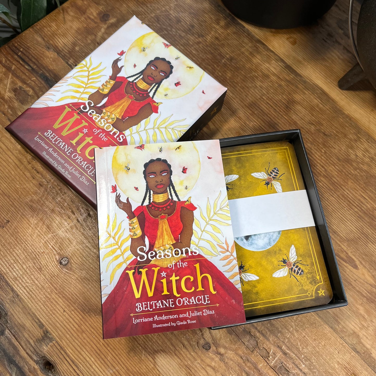 Beltane Oracle card set with packaging on a wooden surface