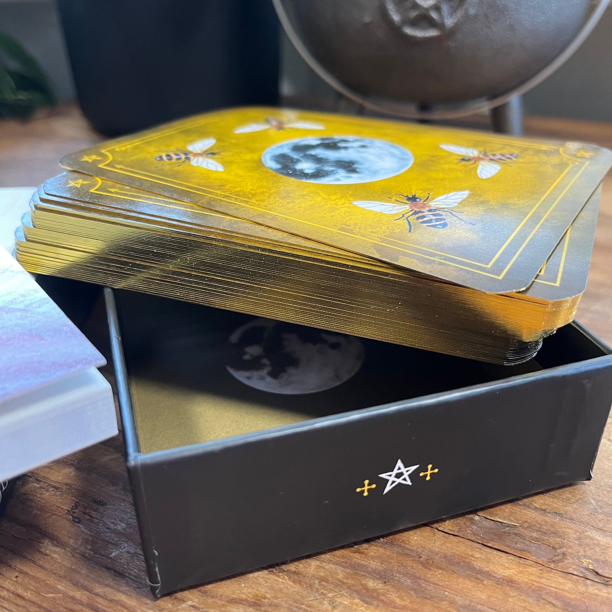 Stack of tarot cards with a black box on a wooden surface