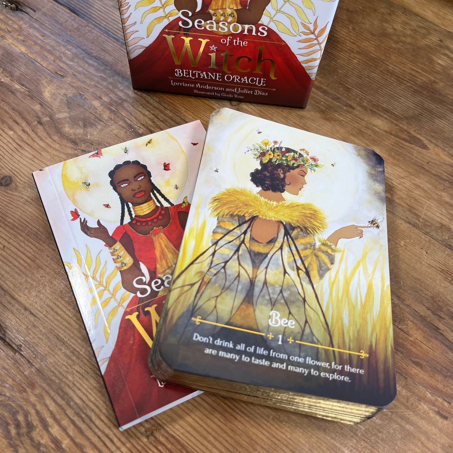 Oracle cards from 'Seasons of the Witch' oracle deck on a wooden surface with the box in the background.