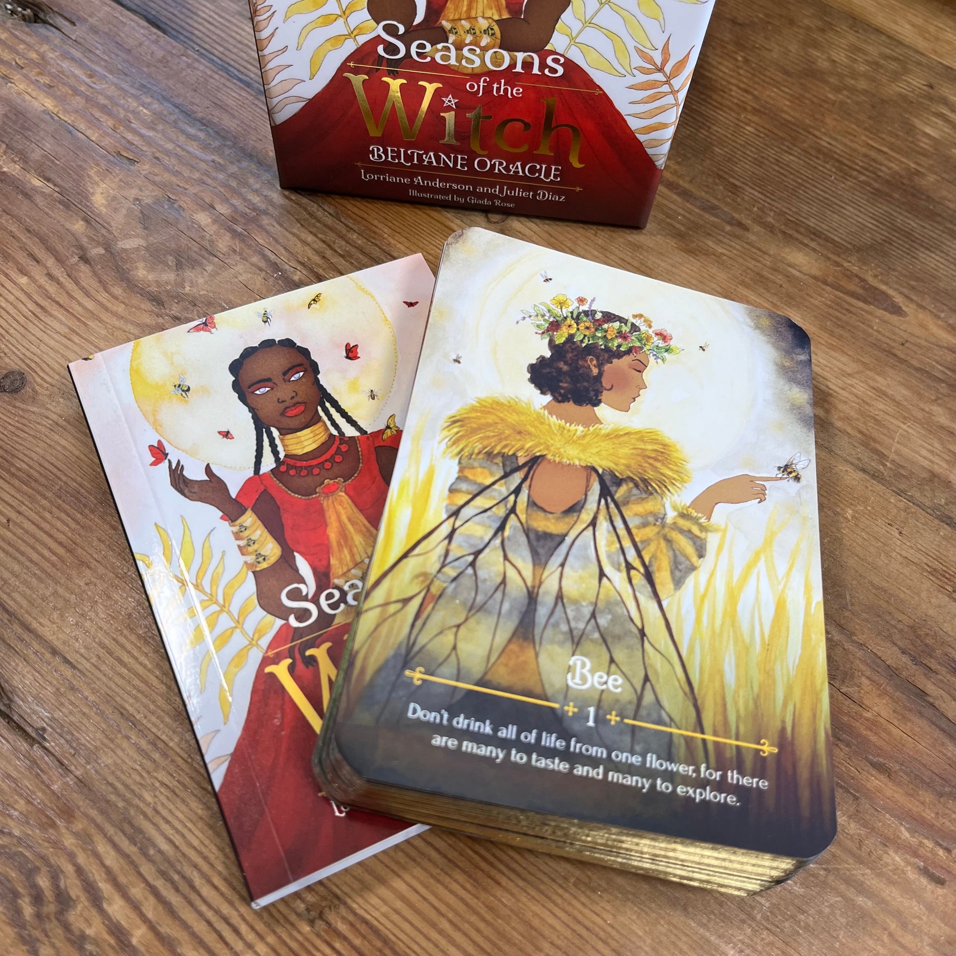 Oracle cards from 'Seasons of the Witch' oracle deck on a wooden surface with the box in the background.