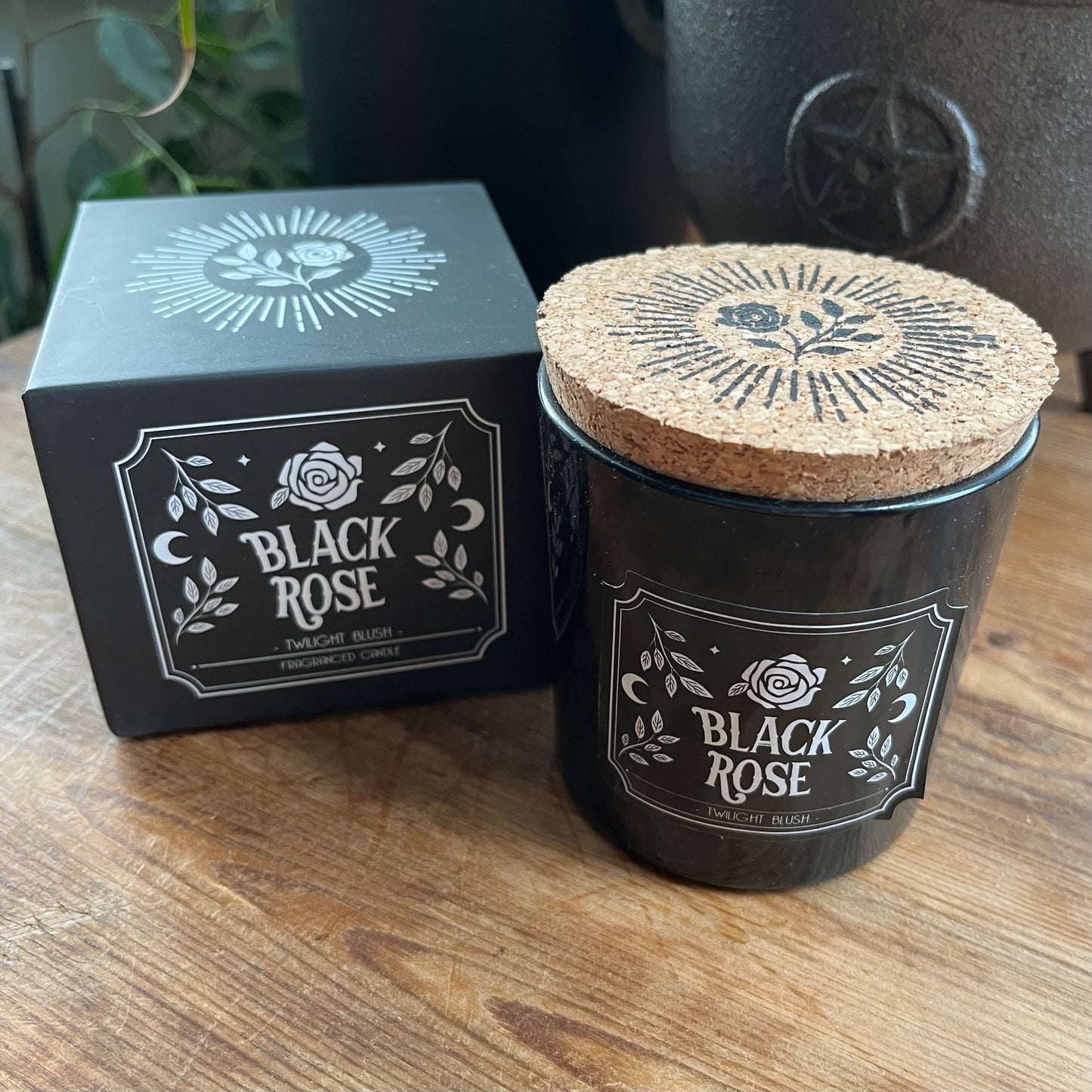 Black Rose candle with cork lid and packaging on a wooden surface
