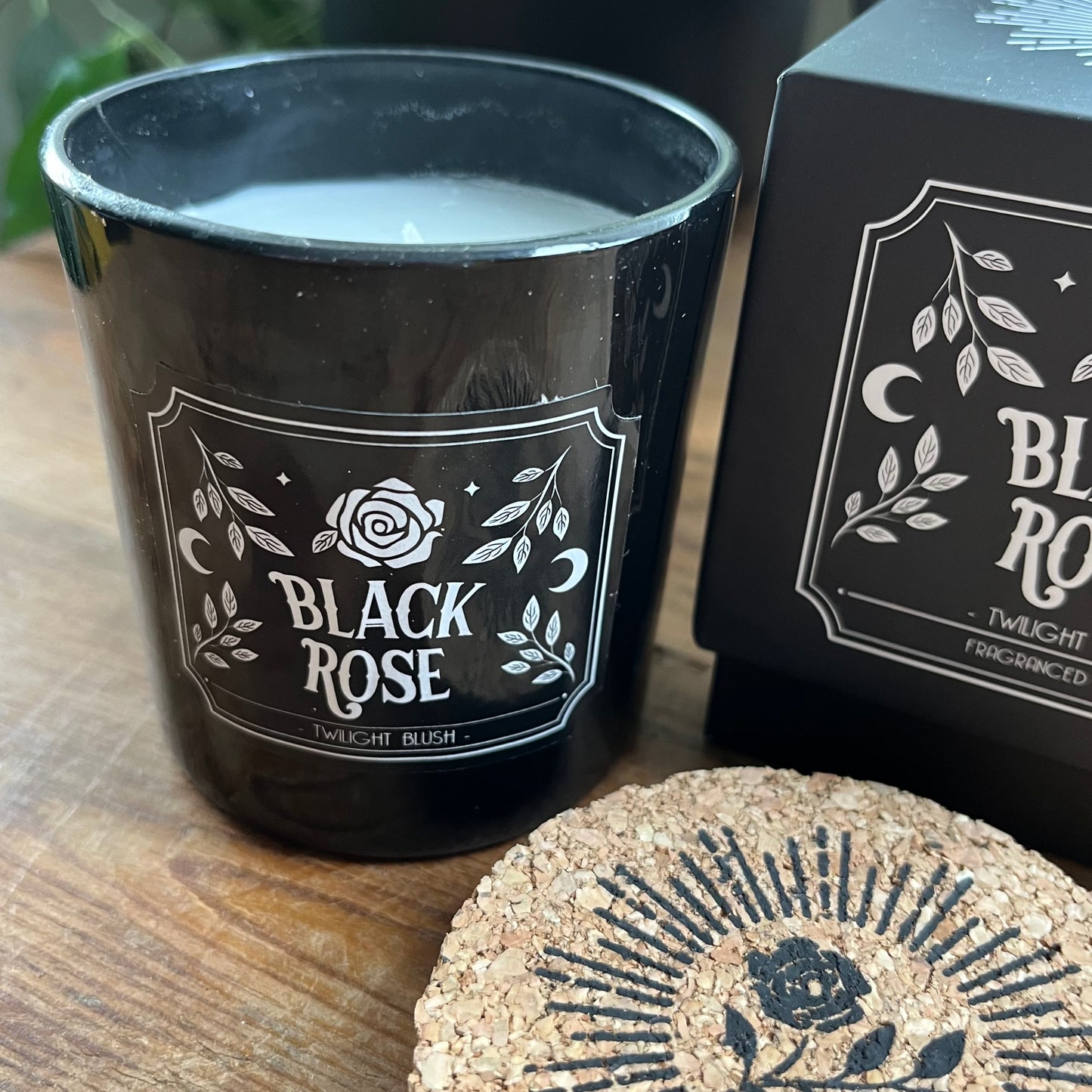 Black Rose candle with a matching sliding box on a wooden surface