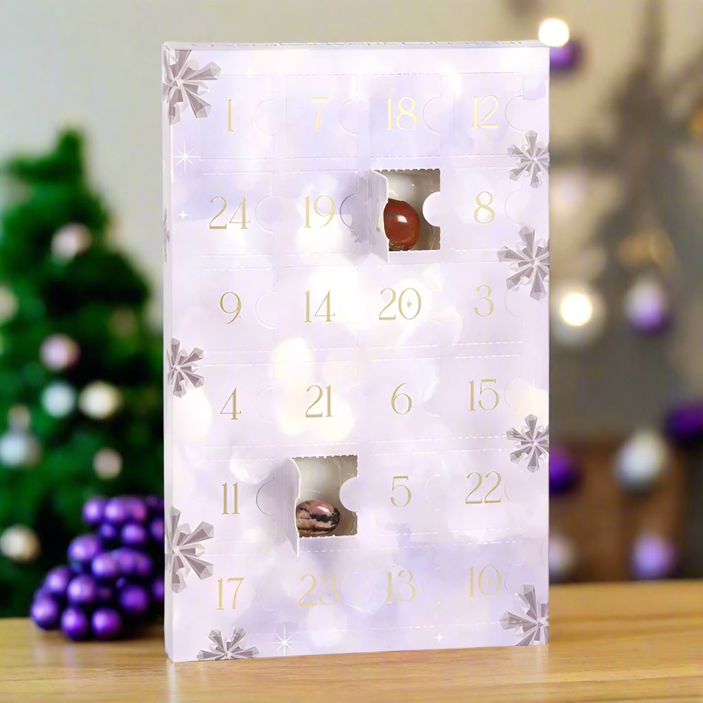 A pale Lilac cardboard advent calendar with 24 numbered doors. Two of the doors are open and a crystal can be seen tucked inside. It is centre of an AI generated image of a christmas scene. 