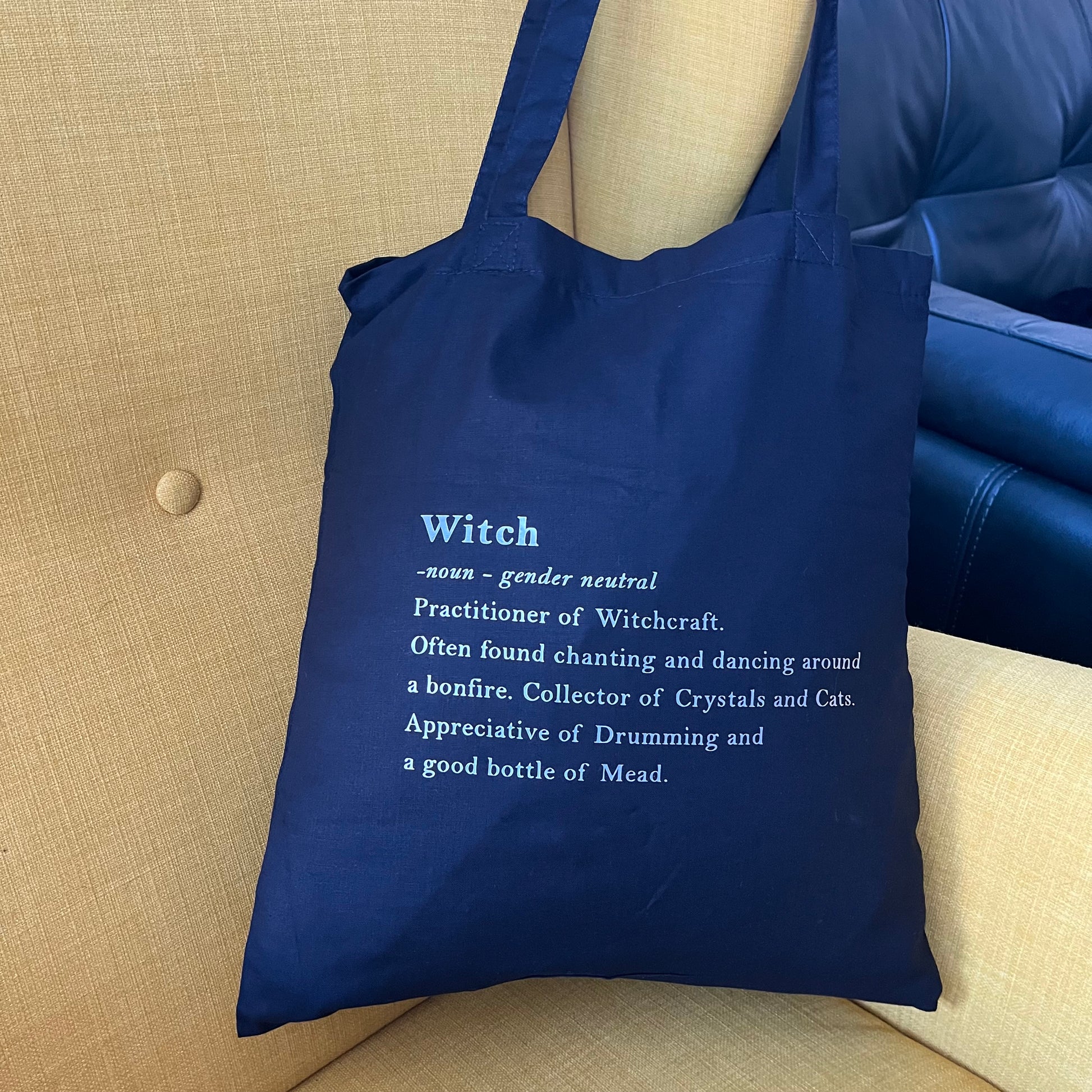 Black tote bag with definition of a witch in white text 