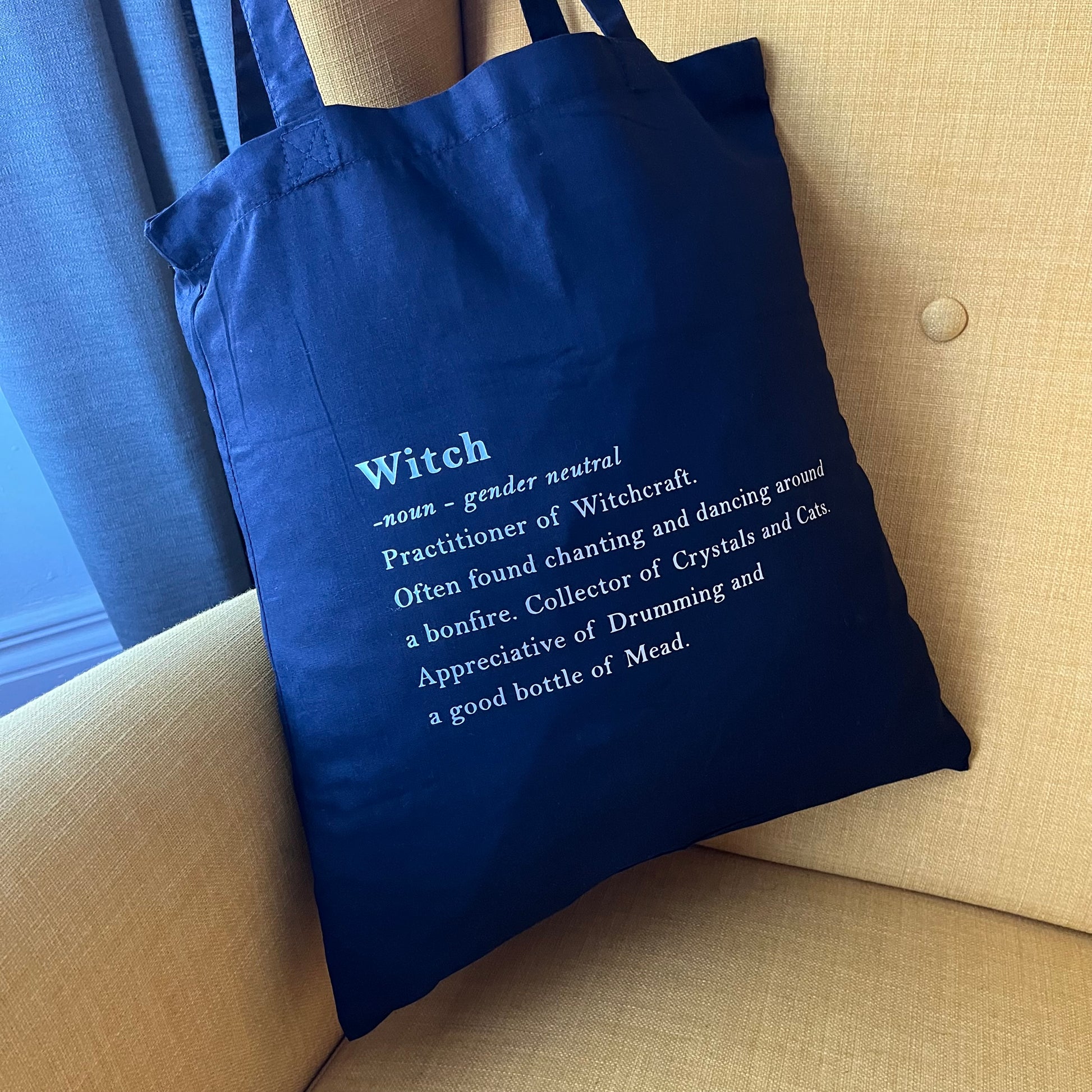 Black tote bag with definition of a witch in white text 