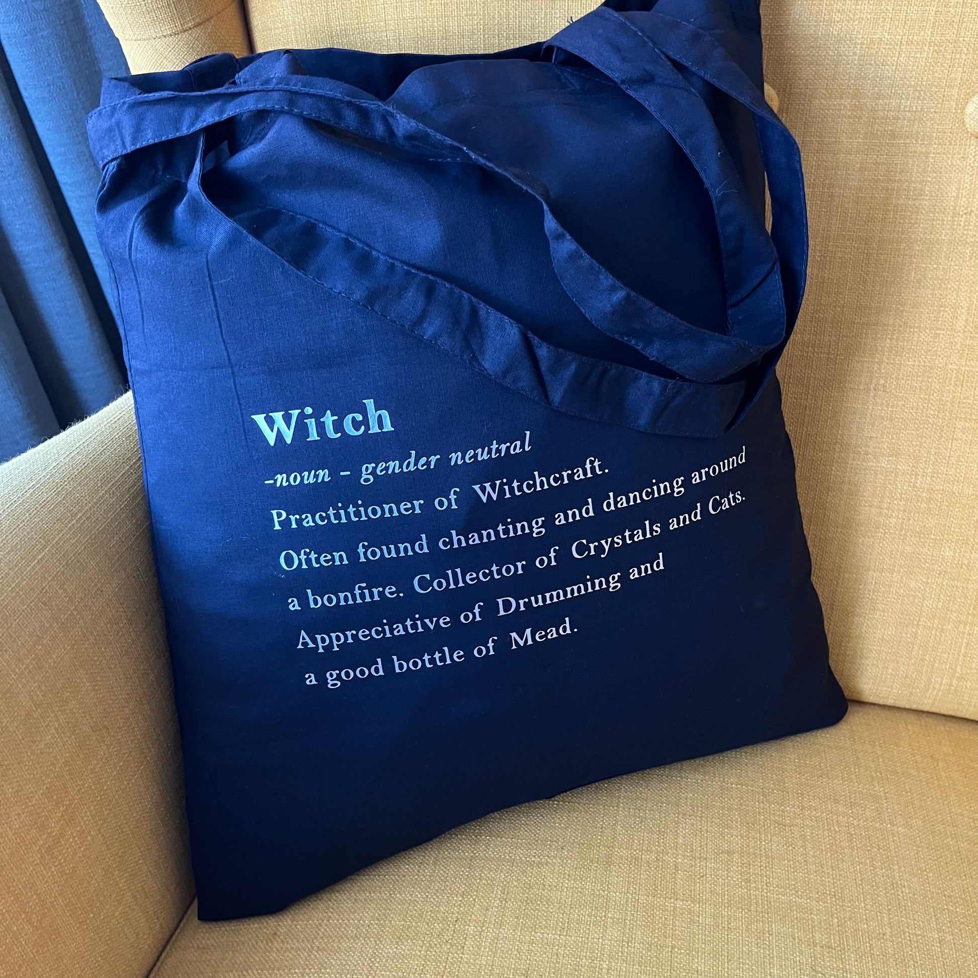 Black tote bag with definition of a witch in white text 