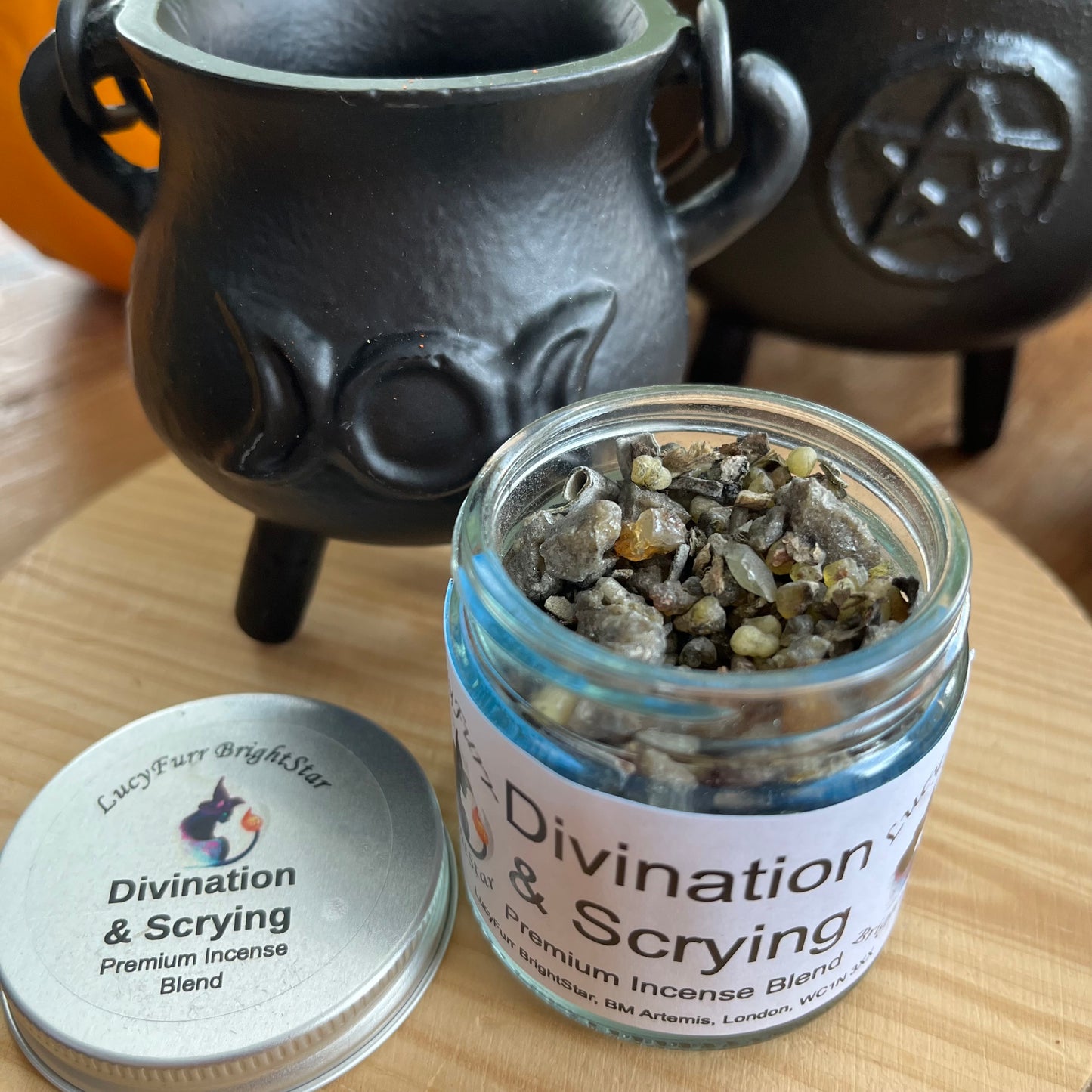 Jar of 'Divination & Scrying' premium incense blend with a black cauldron in the background.