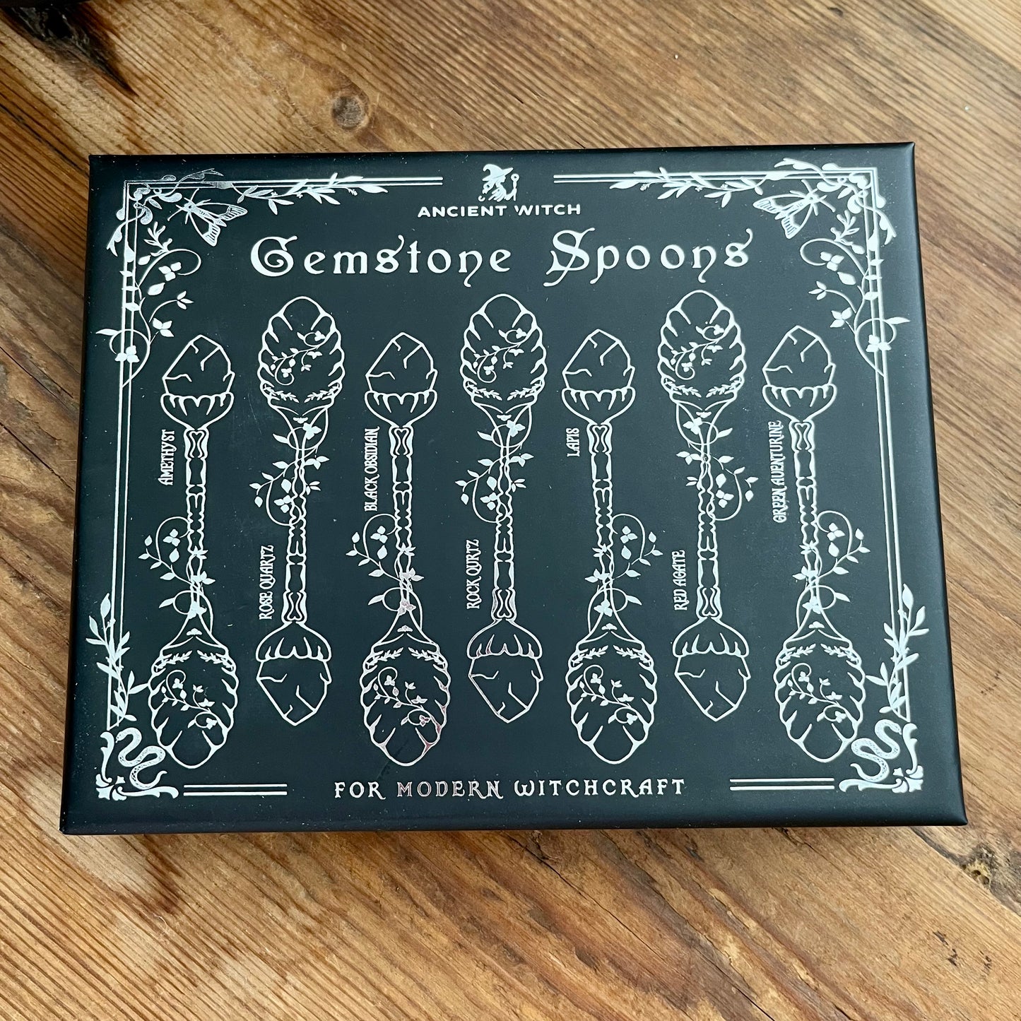 Box of Gemstone Spoons for Modern Witchcraft on a wooden surface
