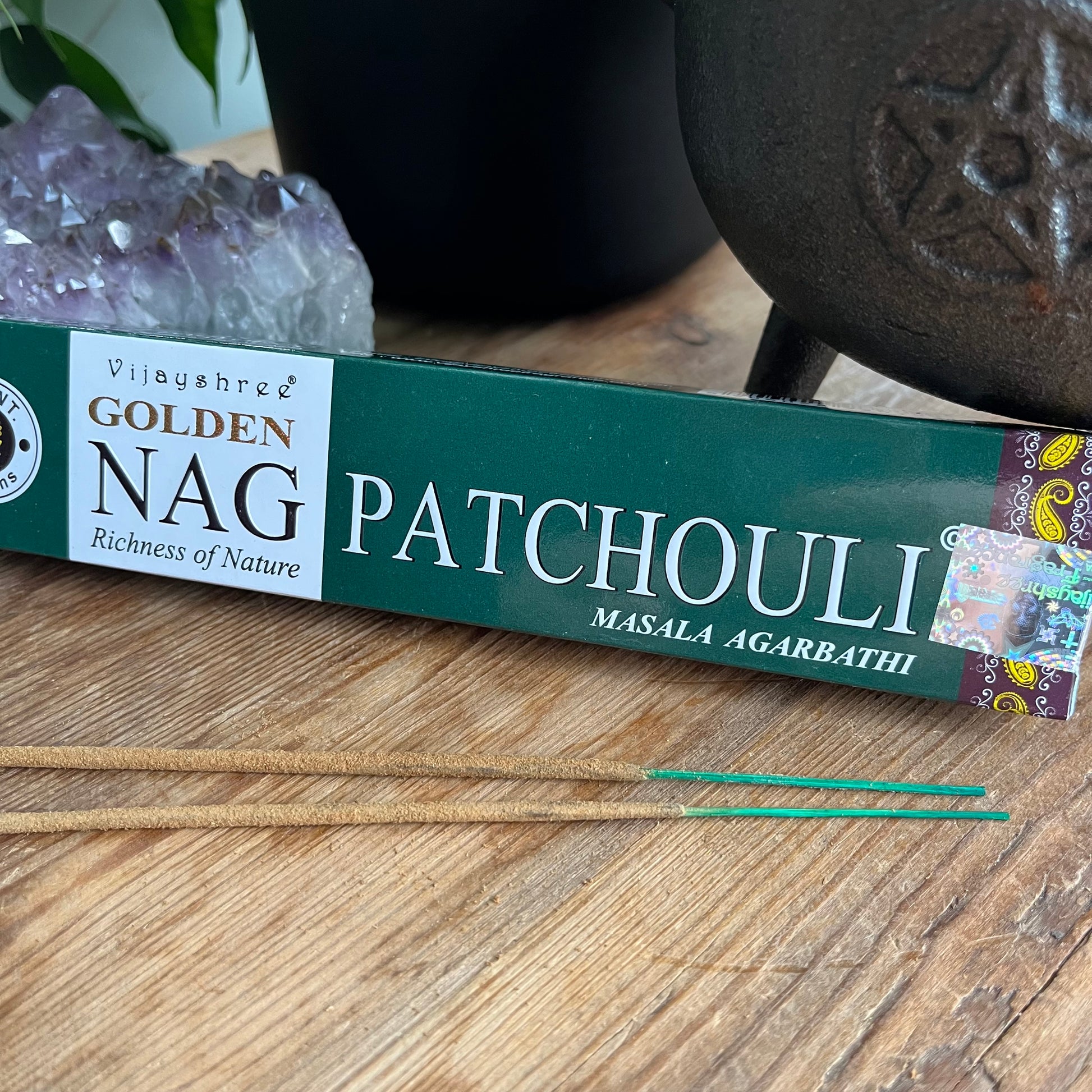 A box of Golden Nag Patchouli incense with a label that includes the product name and the phrase 'Richness of Nature'. alongside some loose incense sticks
