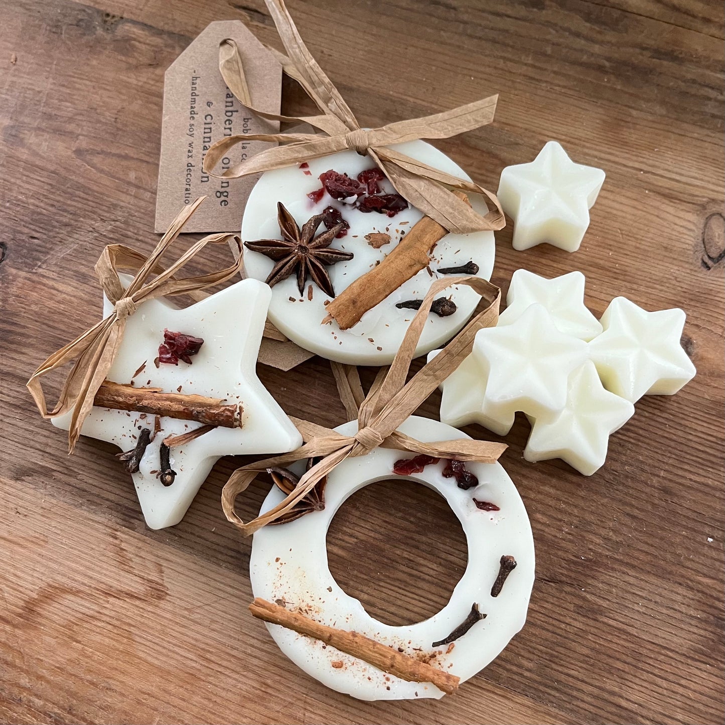 Festive shaped wax melts with cinnamon sticks and star anise on a wooden surface
