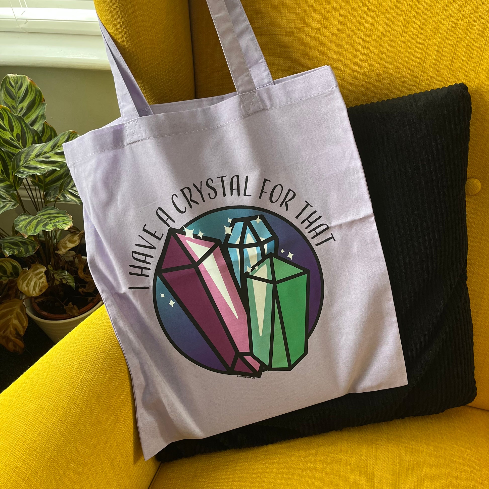 Tote bag with crystal design and text on a yellow couch