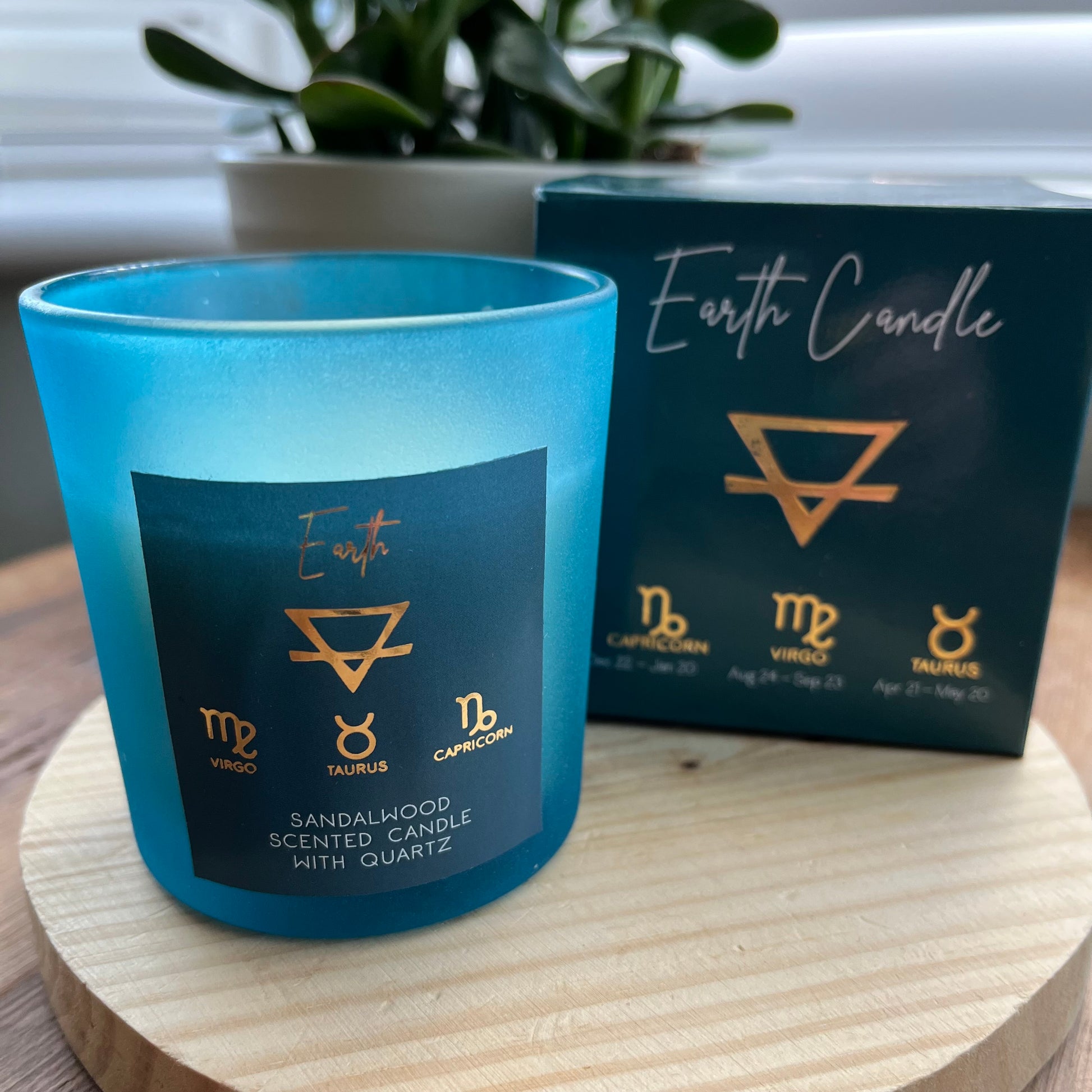 'Earth Element Glass Candle" 'Zodiac Candle' Blue Glass candle holder featuring the word Earth and the symbol for the element of earth plus the symbols for the earthly zodiac signs of Taurus, Virgo and Capricorn. Alongside is its presentation box featuring the same words and symbols