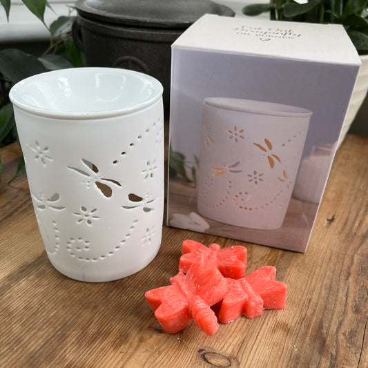 White ceramic oil burner with dragonfly cutouts, with an unglazed finish.  Pictured with dragonfly shaped wax melts 