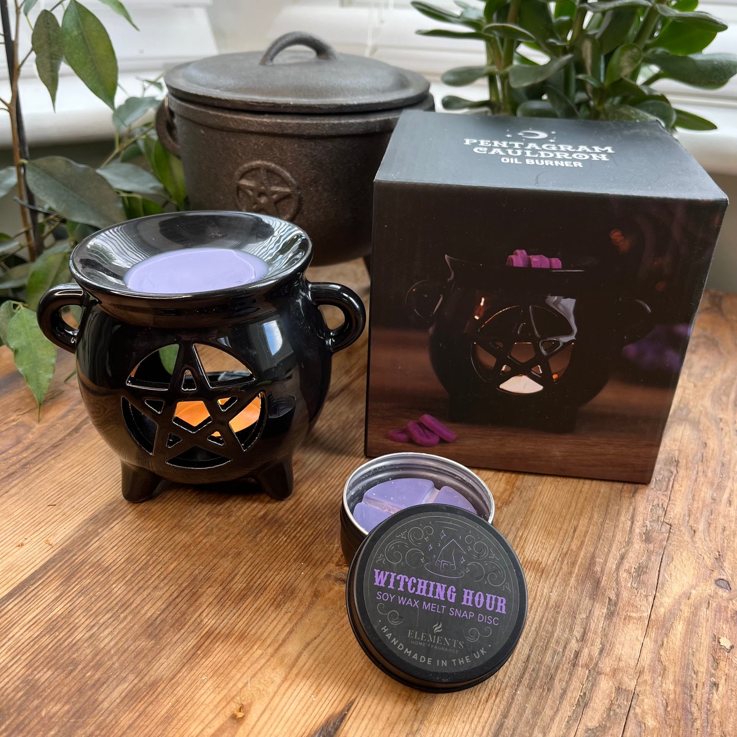 Black shiny ceramic oil burner with pentagram cutout design. Pictured in use with wax melts. 