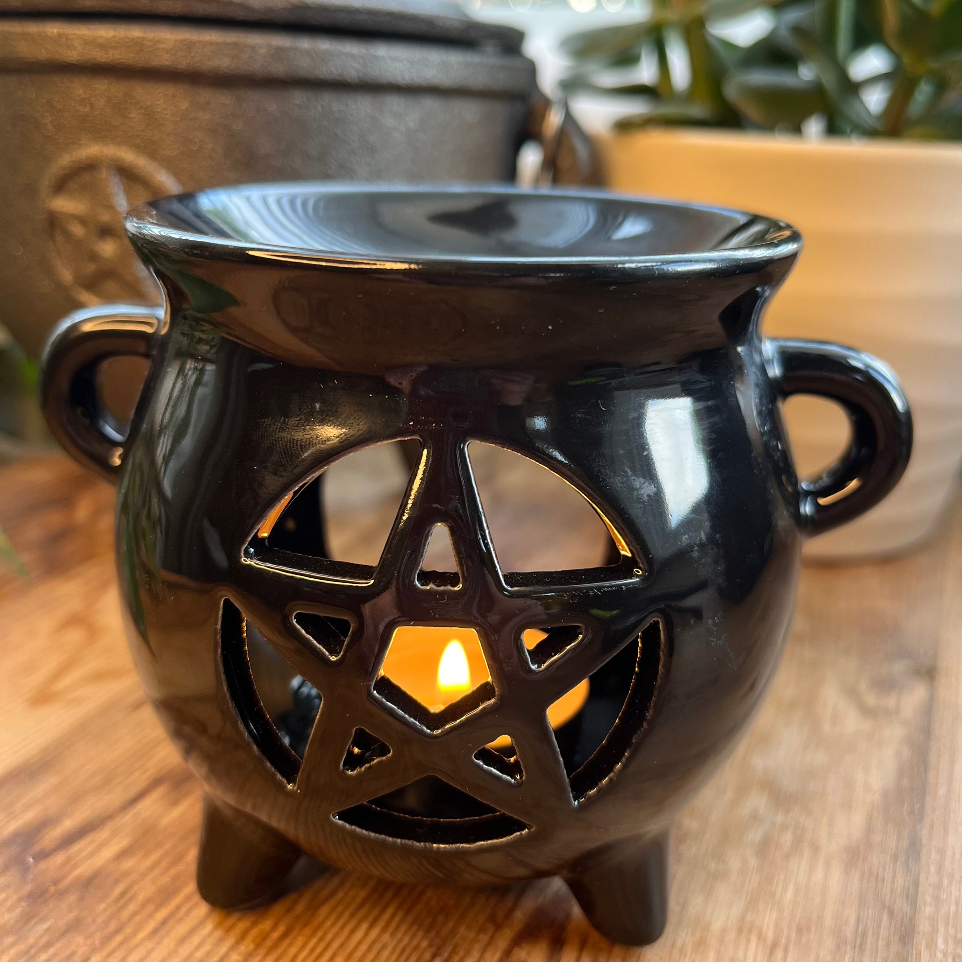 Black shiny ceramic oil burner with pentagram cutout design.