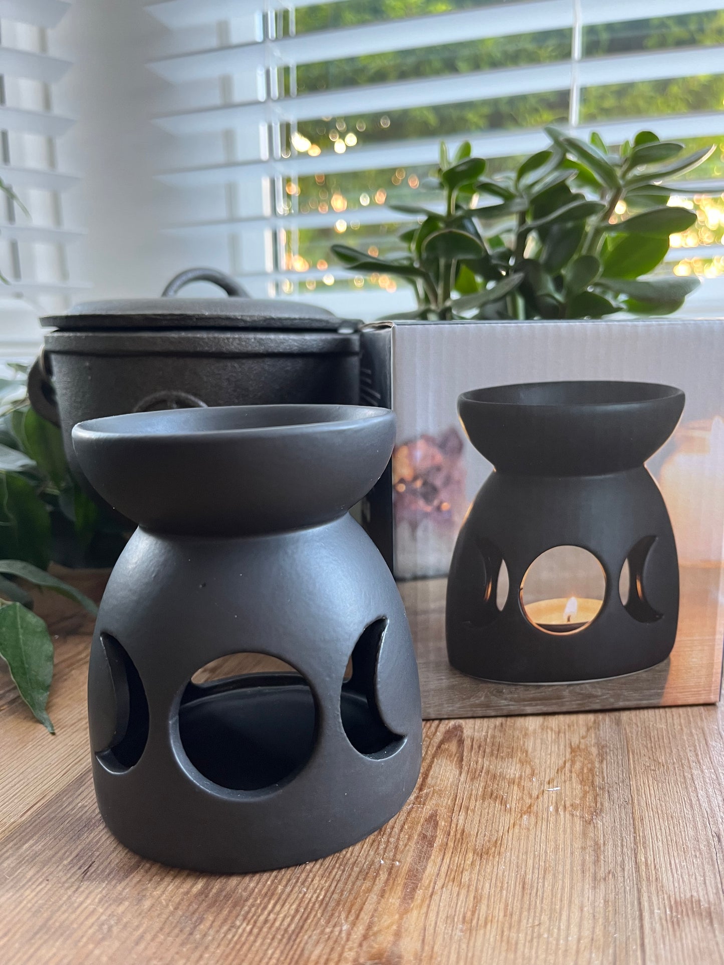 Black ceramic oil burner with a cutout triple moon design and a cool, matt finish.