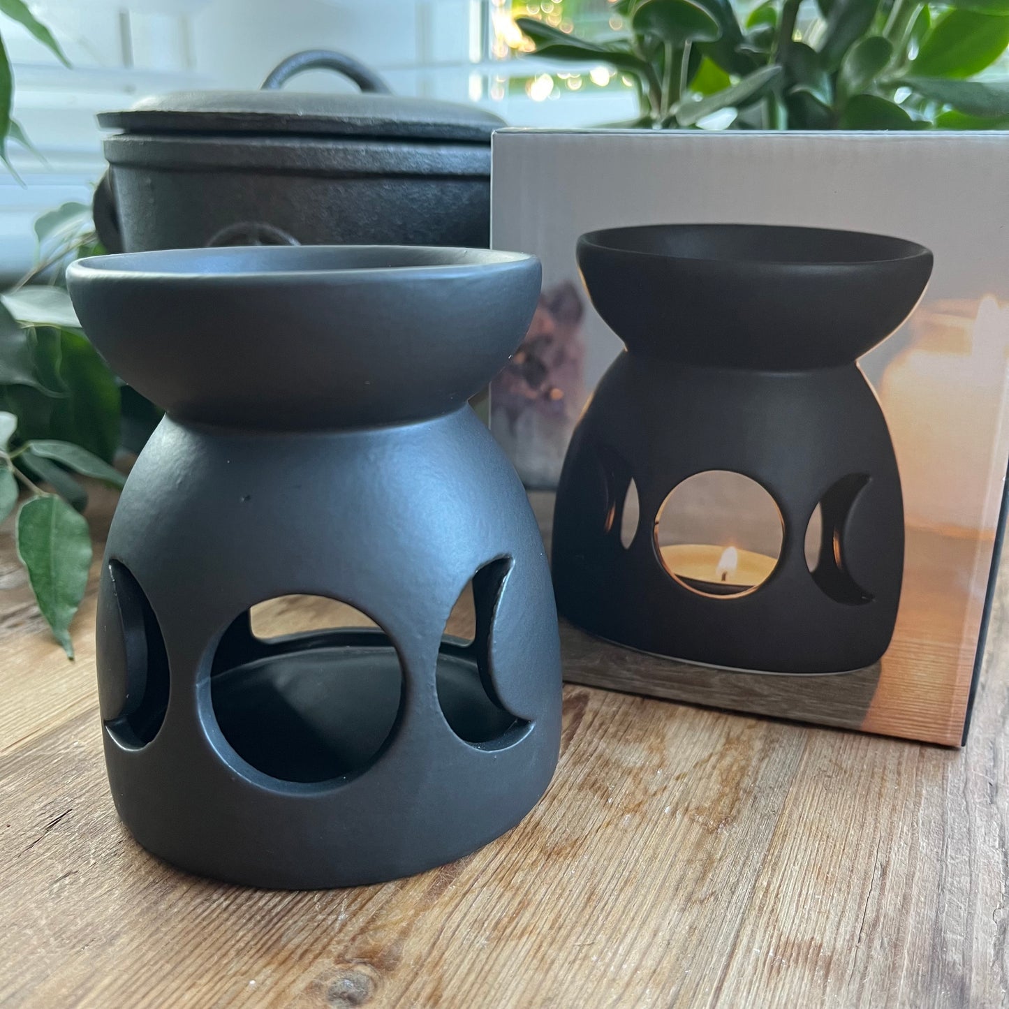 Black ceramic oil burner with a cutout triple moon design and a cool, matt finish.