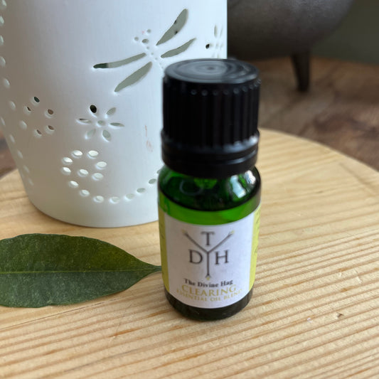 The Divine Hag Clearing Essential Oil Blend 10mls pictured next to an essential oil Burner