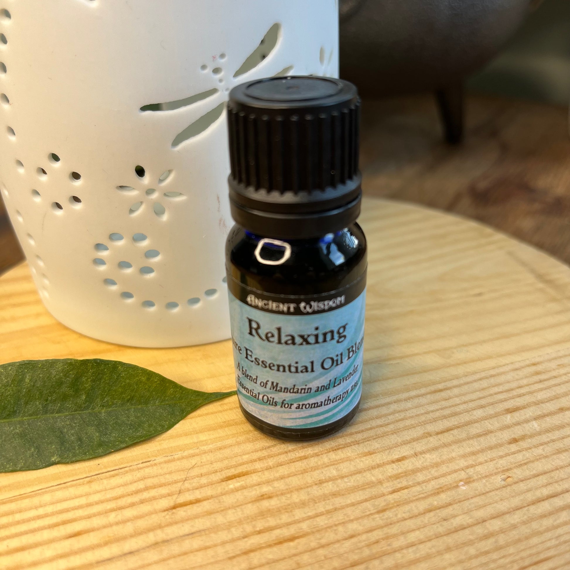 Bottle containing Relaxing Essential Oil Blend next to an oil burner