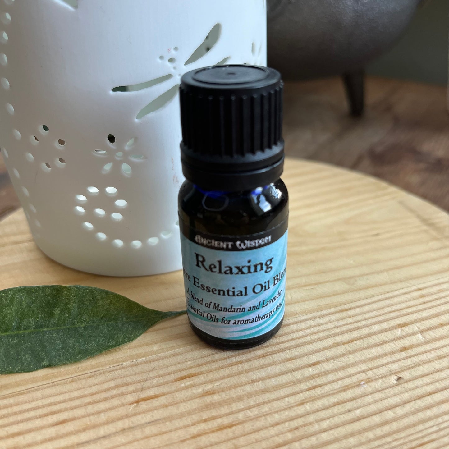 Bottle containing Relaxing Essential Oil Blend next to an oil burner