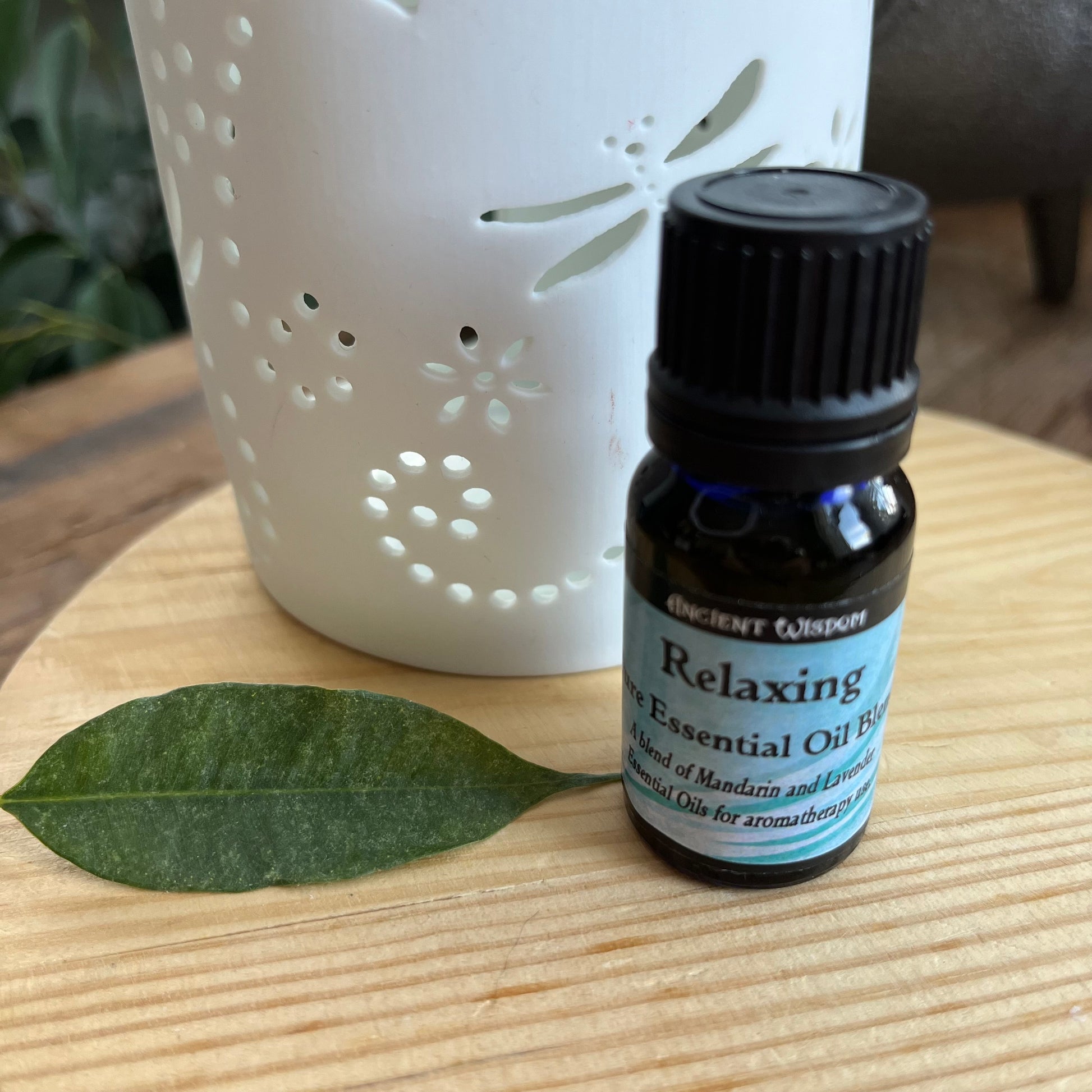 Bottle containing Relaxing Essential Oil Blend next to an oil burner